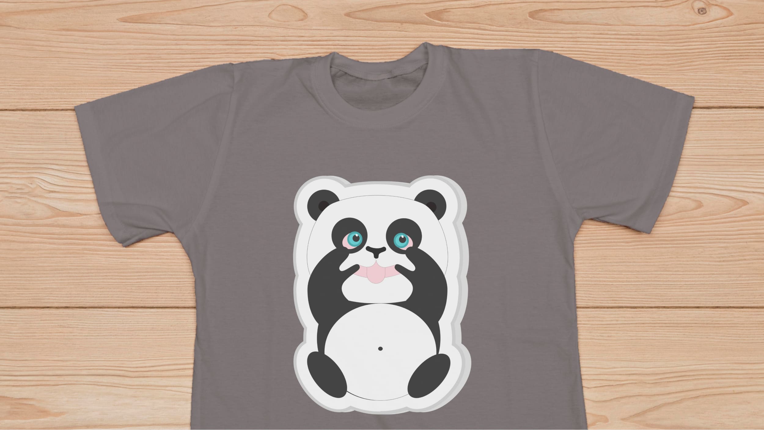 Gray t-shirt with funny panda bear on a wooden background.