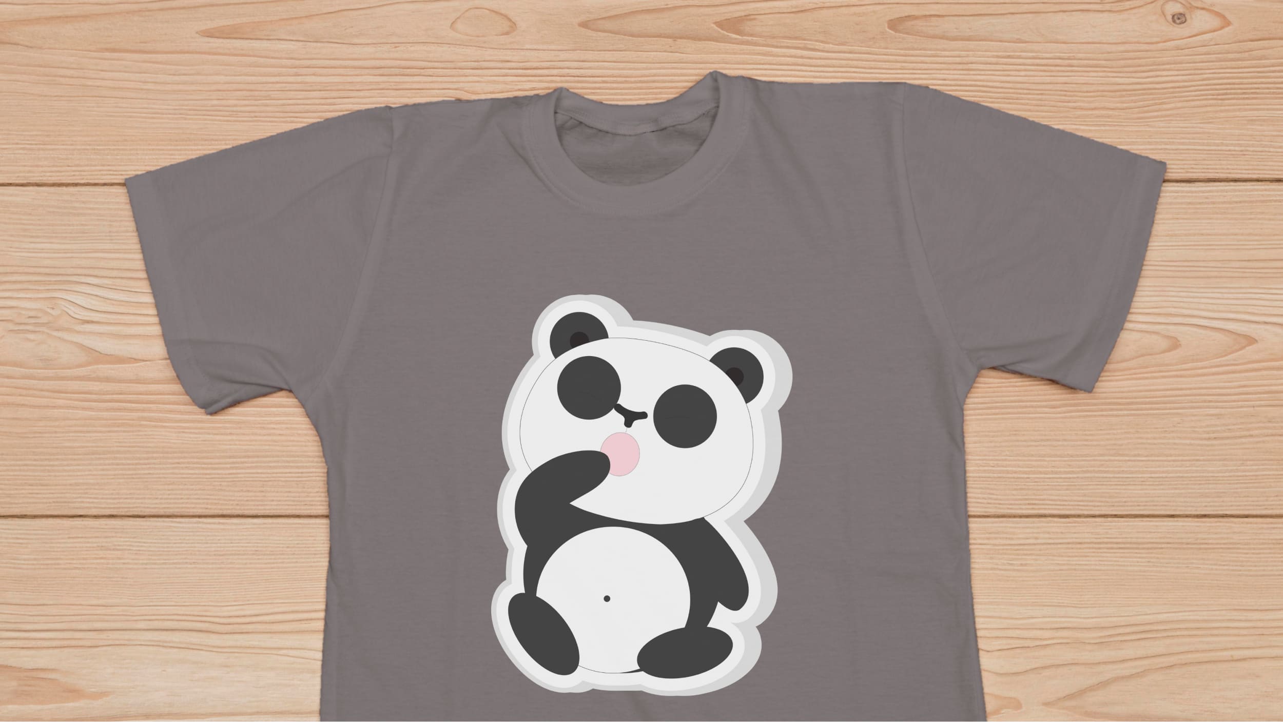 Gray t-shirt with panda bear on a wooden background.
