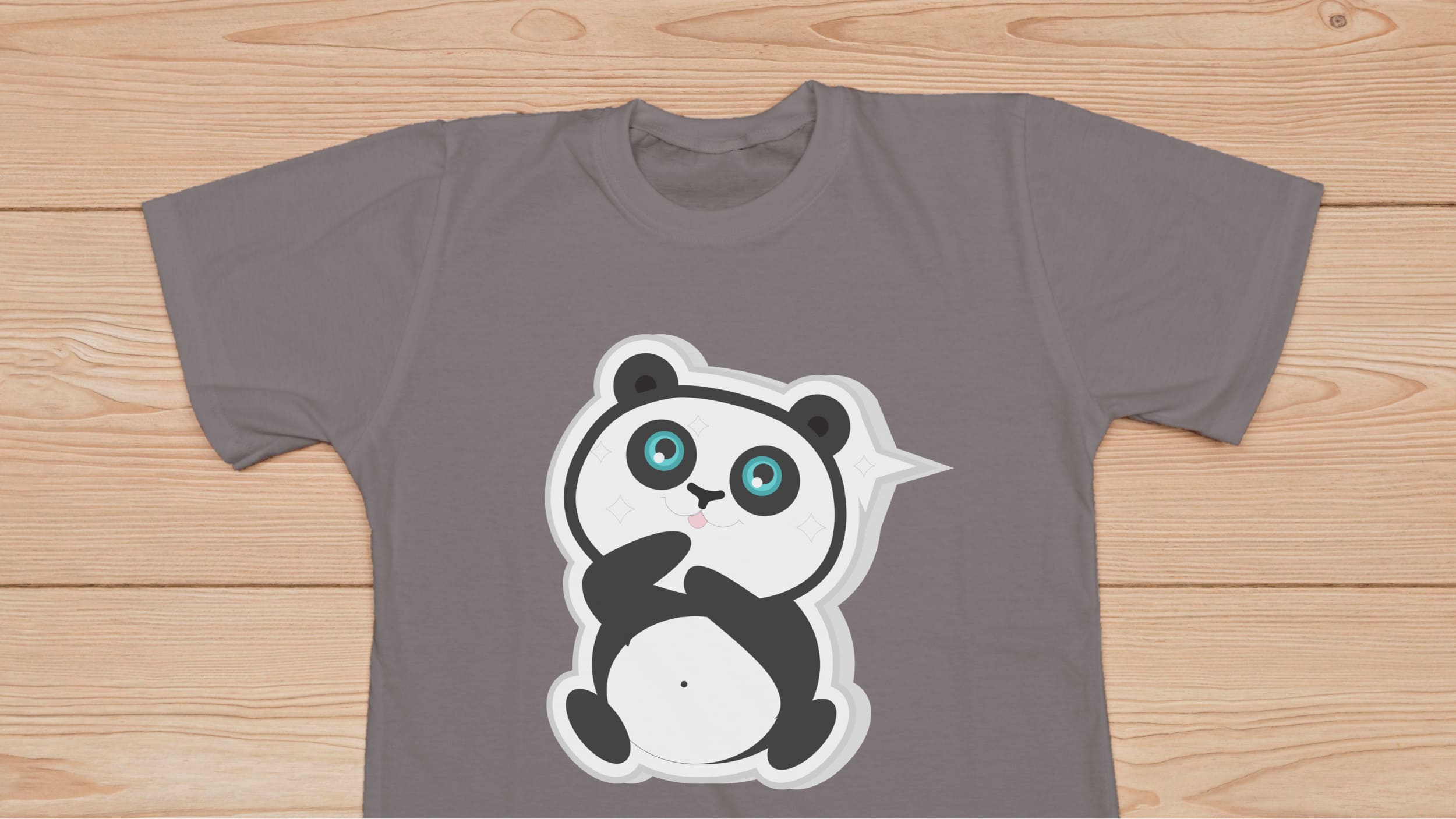 Gray t-shirt with dreamed panda bear on a wooden background.