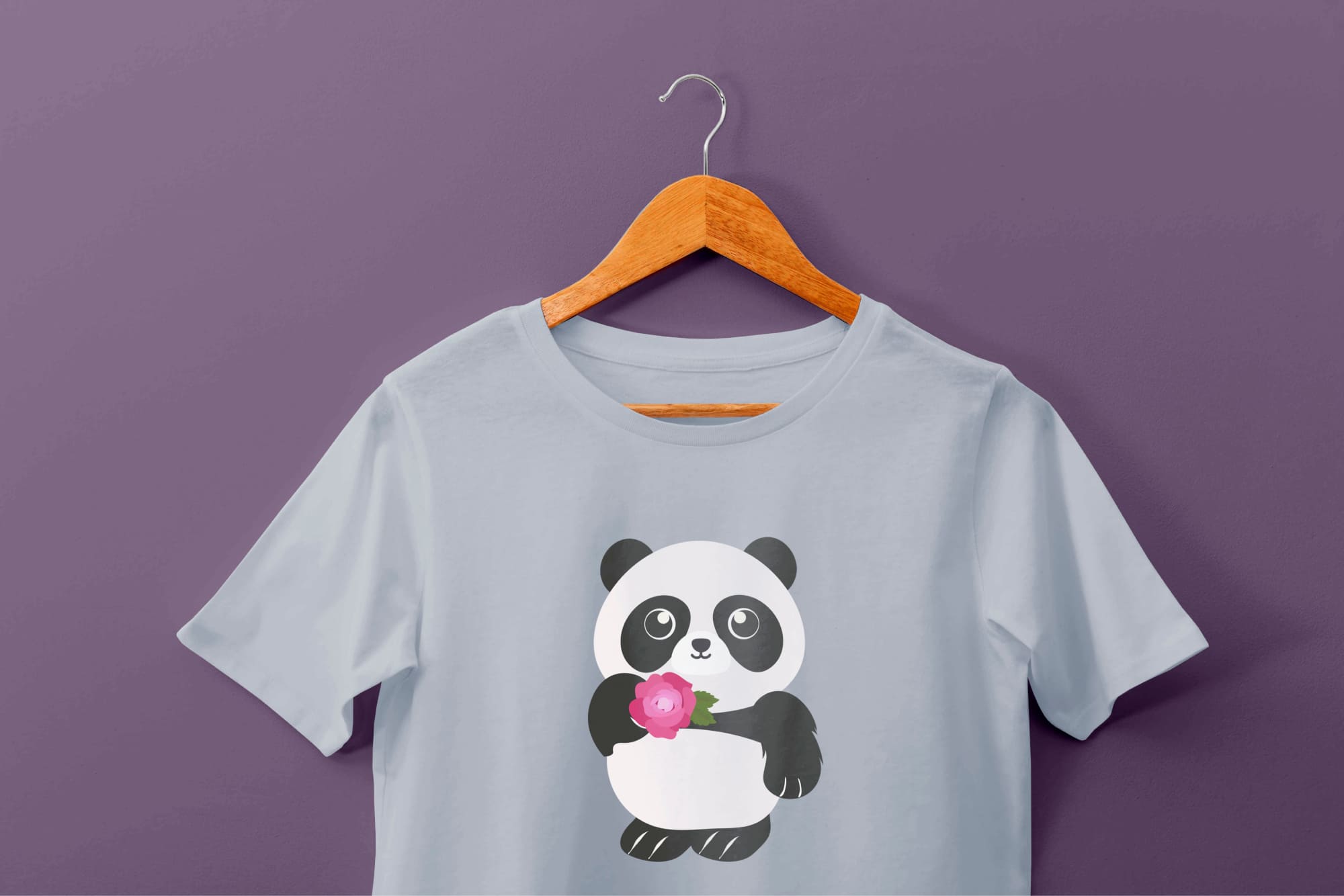 Light blue t-shirt with a panda and pink flower on a hanger on a purple background.