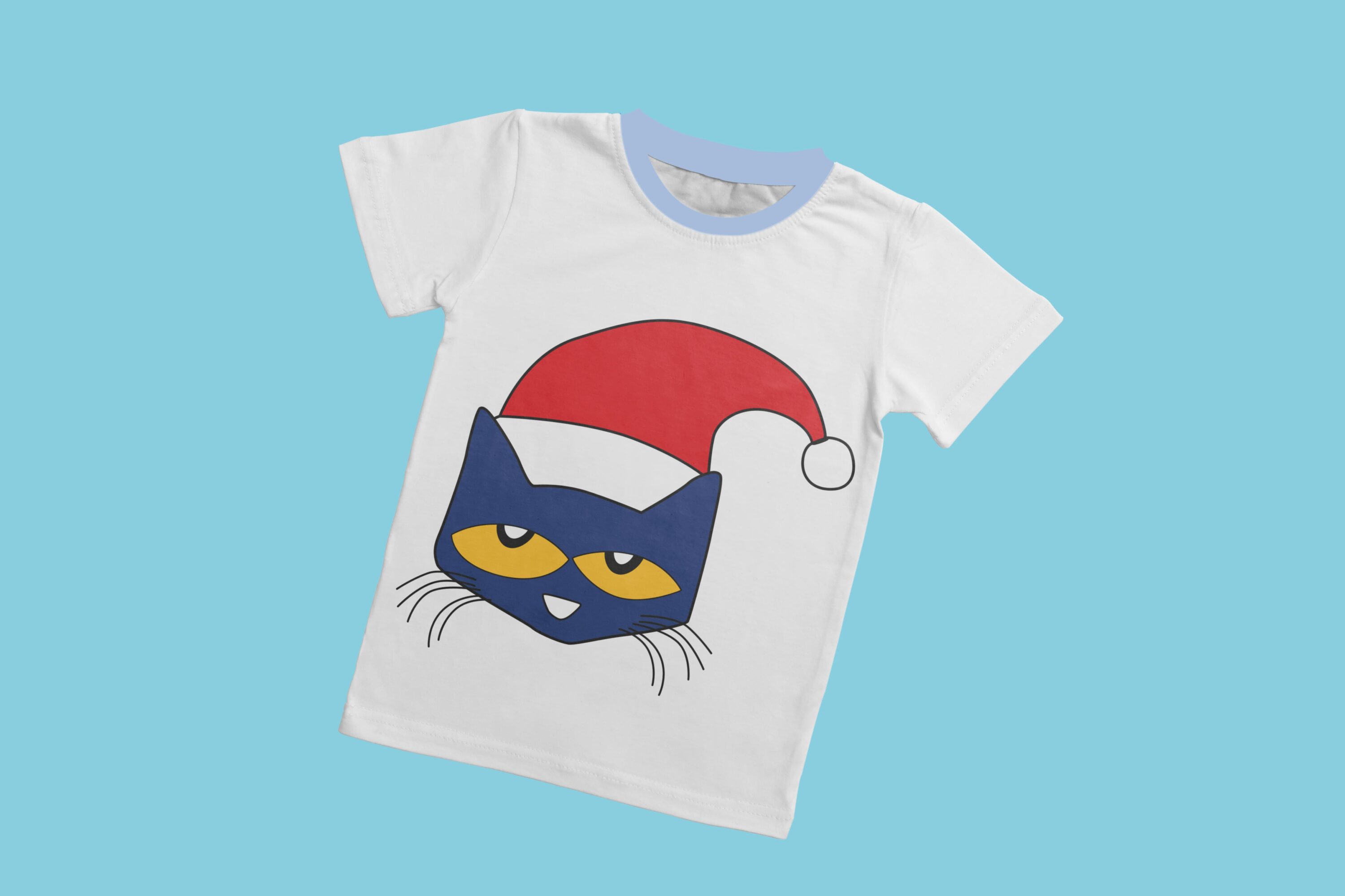 A white t-shirt with a light blue collar and the face of Pete the cat with yellow eyes and a red Christmas cap.