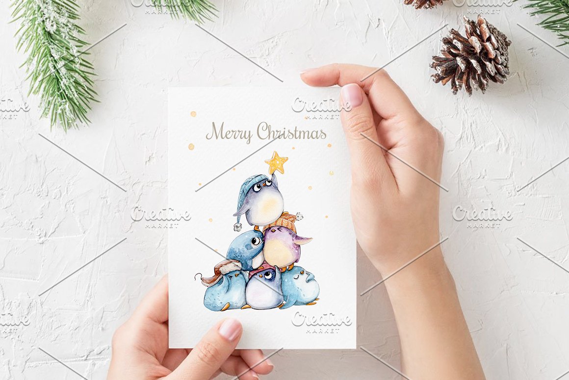 A greeting card with blue lettering "Merry Christmas" and an illustration of penguins.