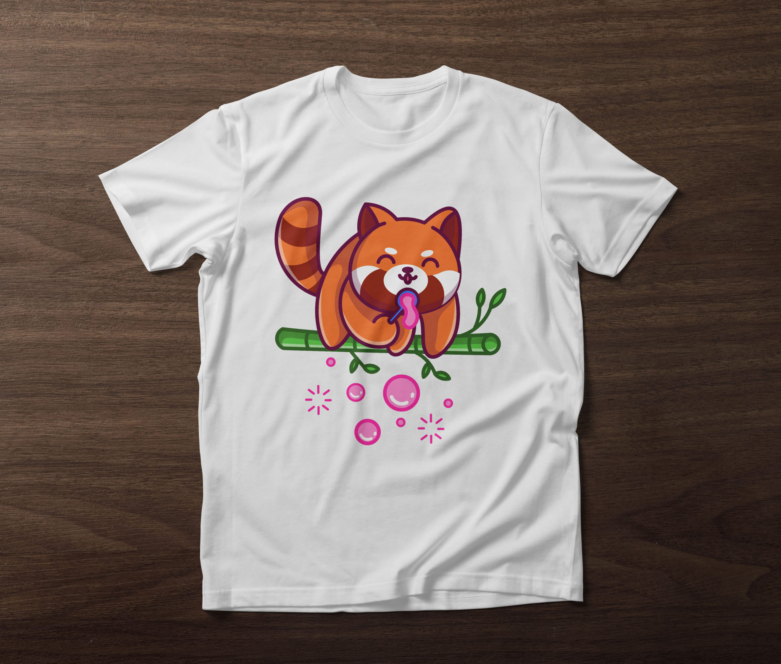 White t-shirt with a red panda and bubble blowers on a wooden background.