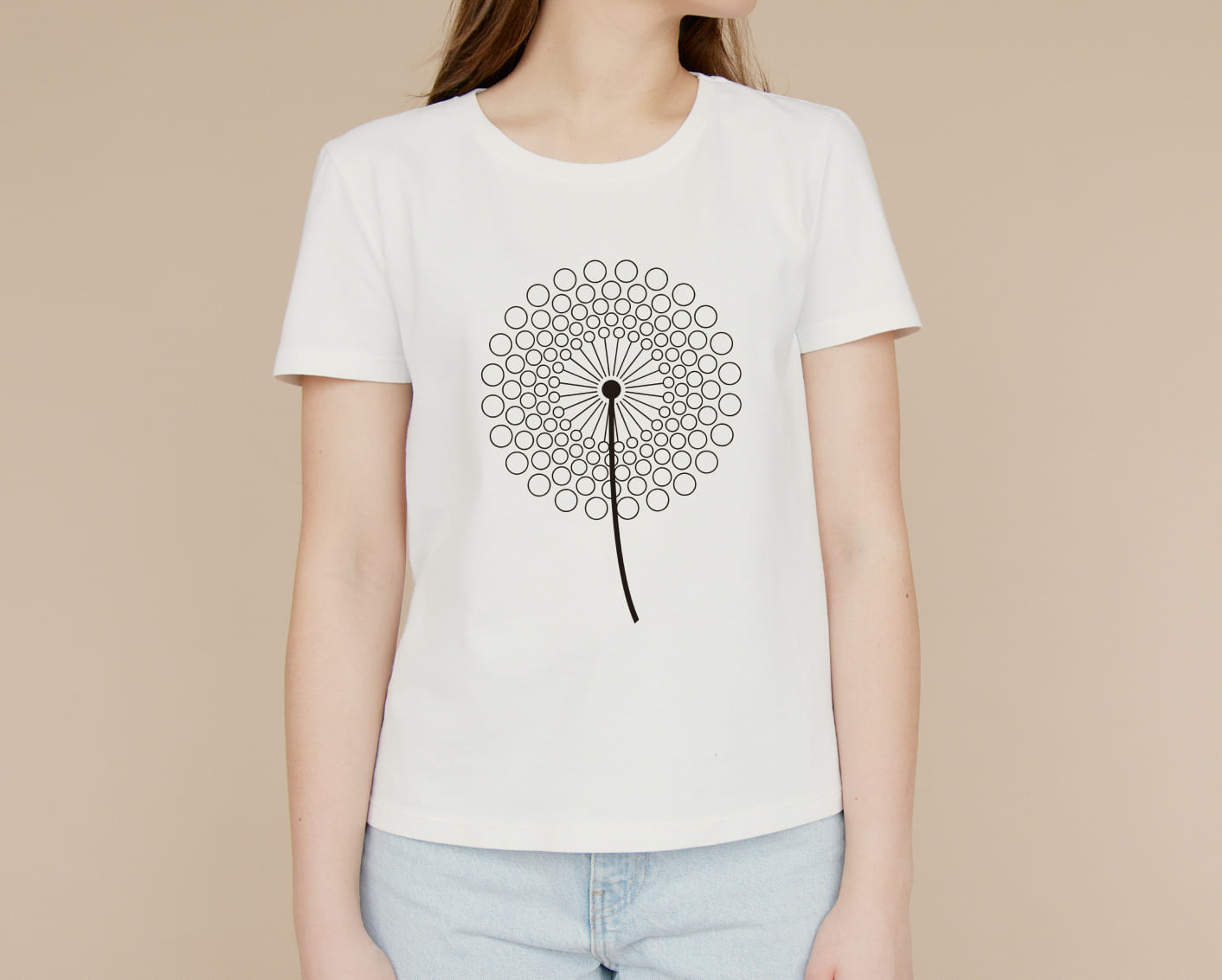 A white T-shirt with a black silhouette of a dandelion flower on a girl on a beige background.