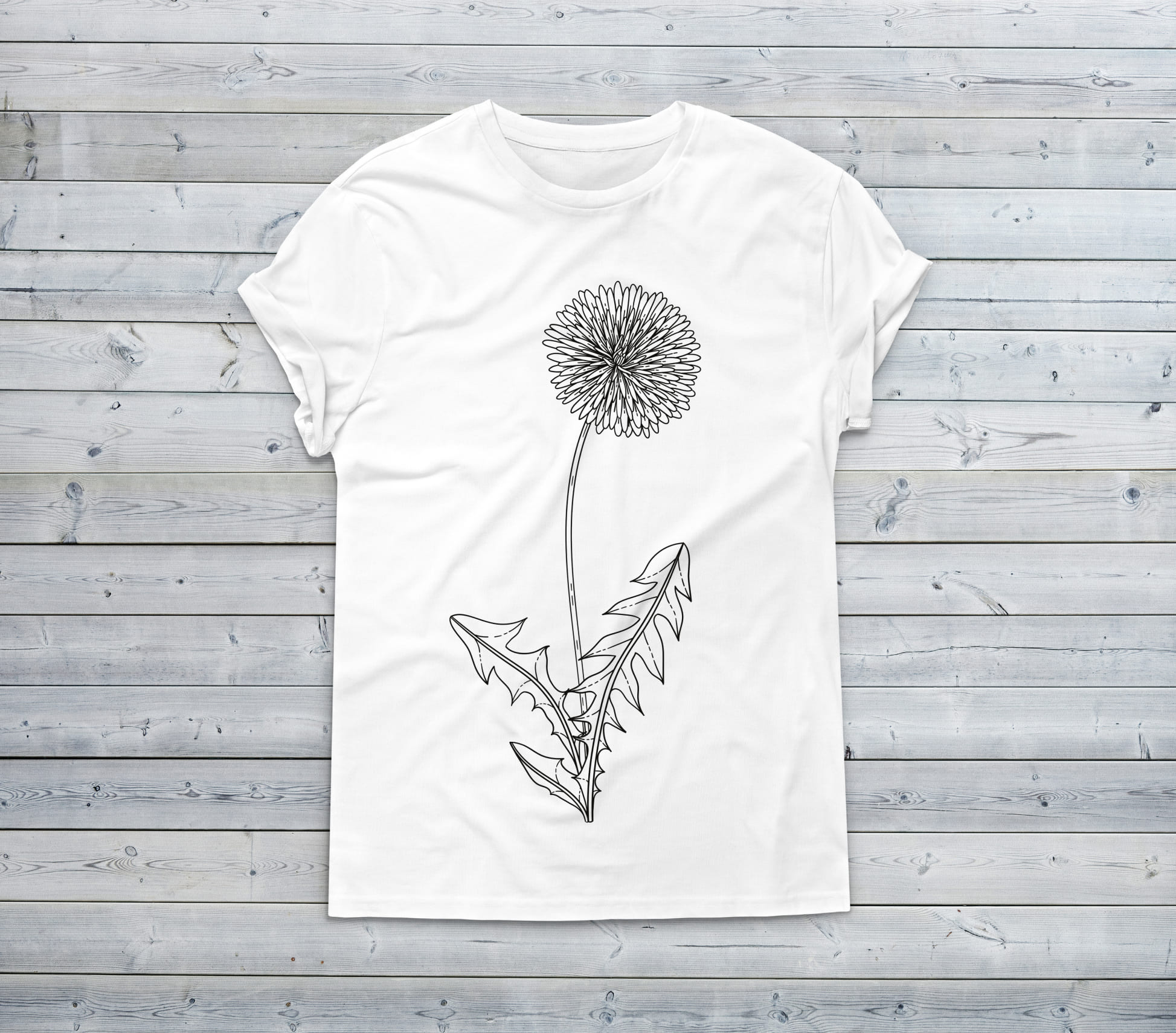 A white t-shirt with a simple dandelion flower on a wooden background.