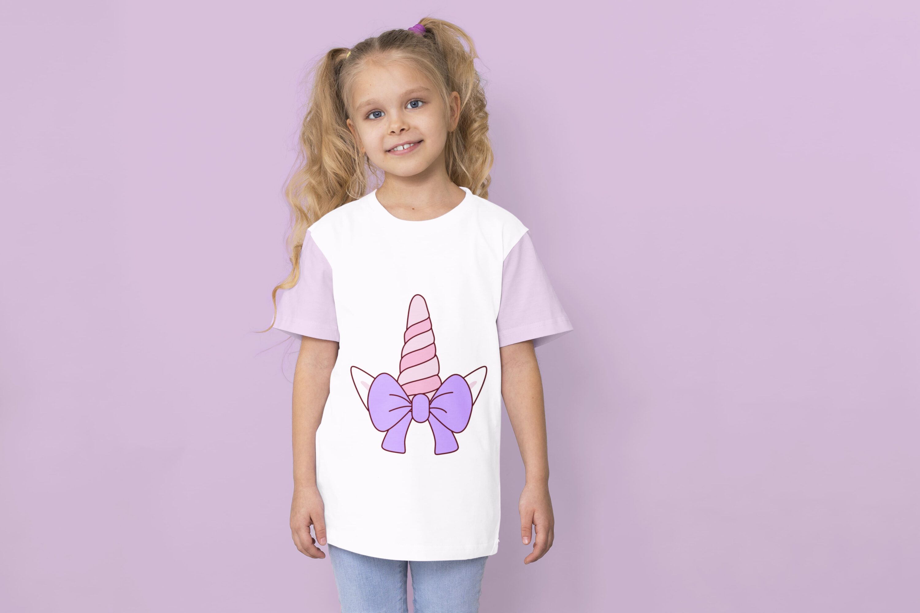 A white t-shirt with lavender sleeves and a pink unicorn horn with a purple bow on a girl against a lavender background.