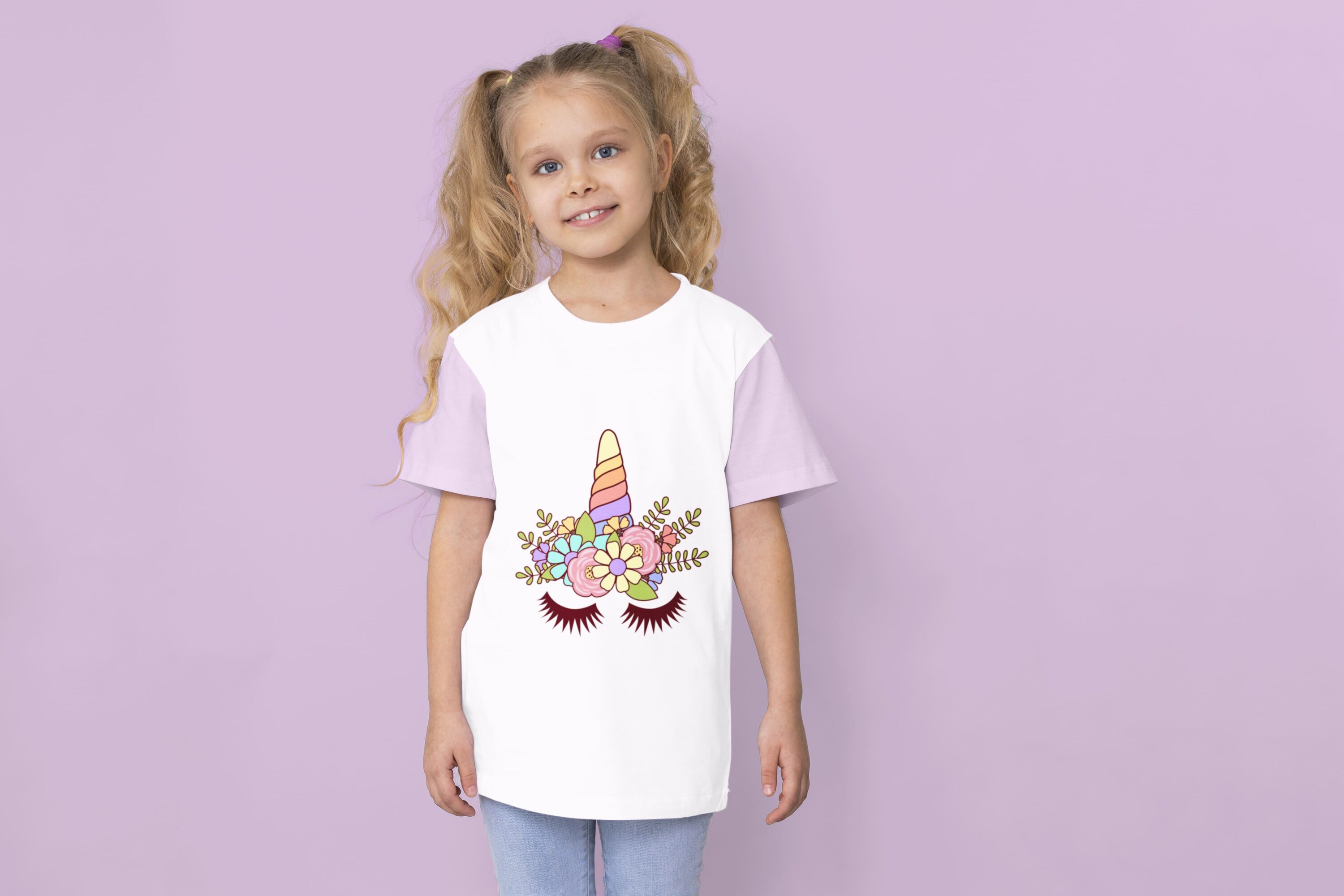 A white t-shirt with lavender sleeves and a colorful unicorn horn with closed eyes on a girl against a lavender background.