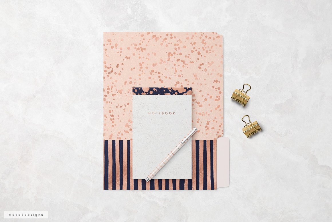 Notebook of pink gold patterns on a gray background.