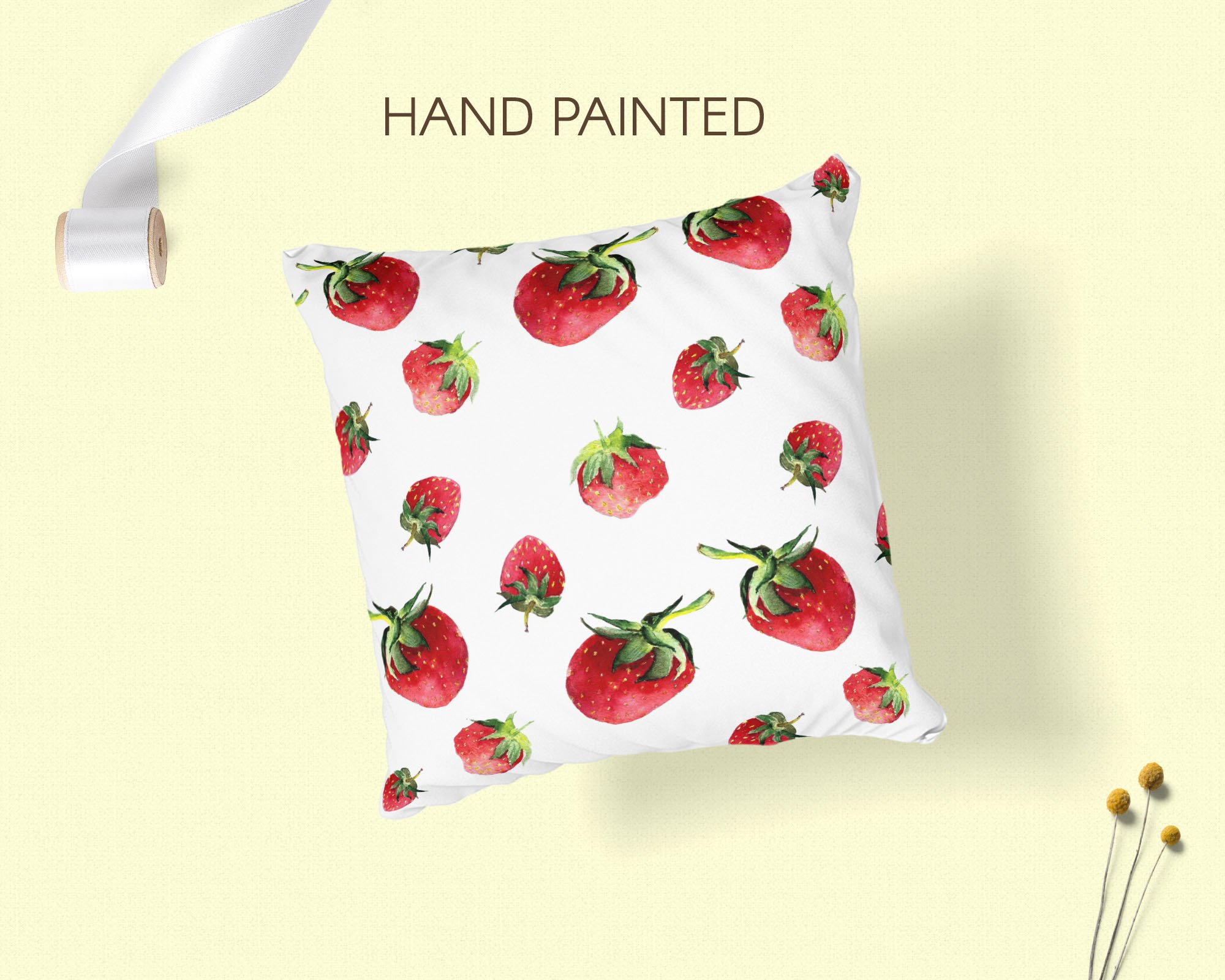 Black lettering "Hand painted" and white pillow with illustrations of a strawberry.