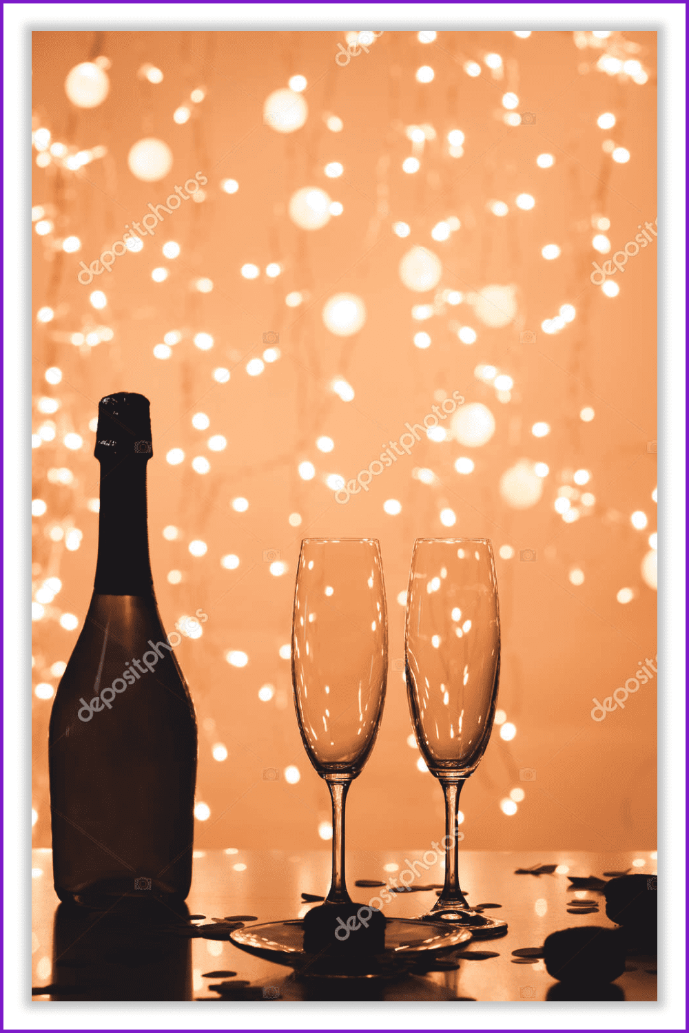 A bottle of champagne and two glasses against the background of yellow garlands.