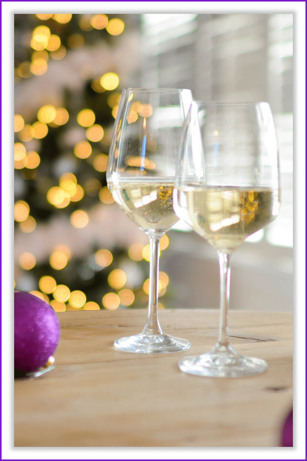Two glasses of champagne on the table against the background of the Christmas tree.
