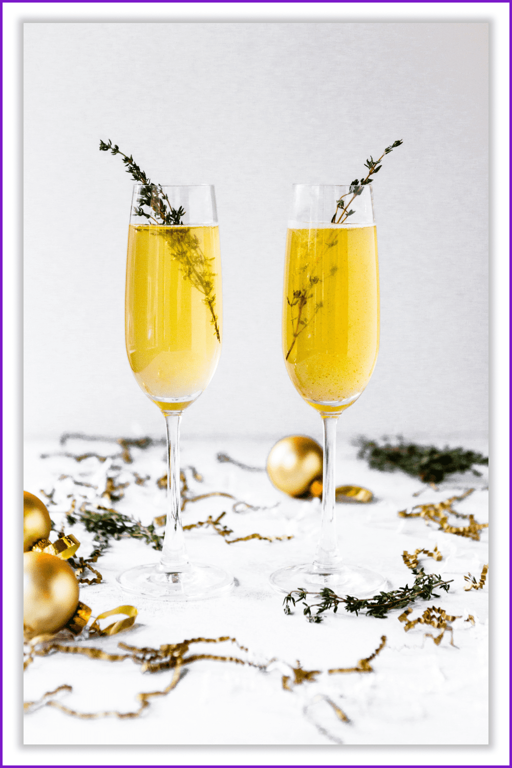 Two glasses of champagne with sprigs of lavender on a white table with decoration.