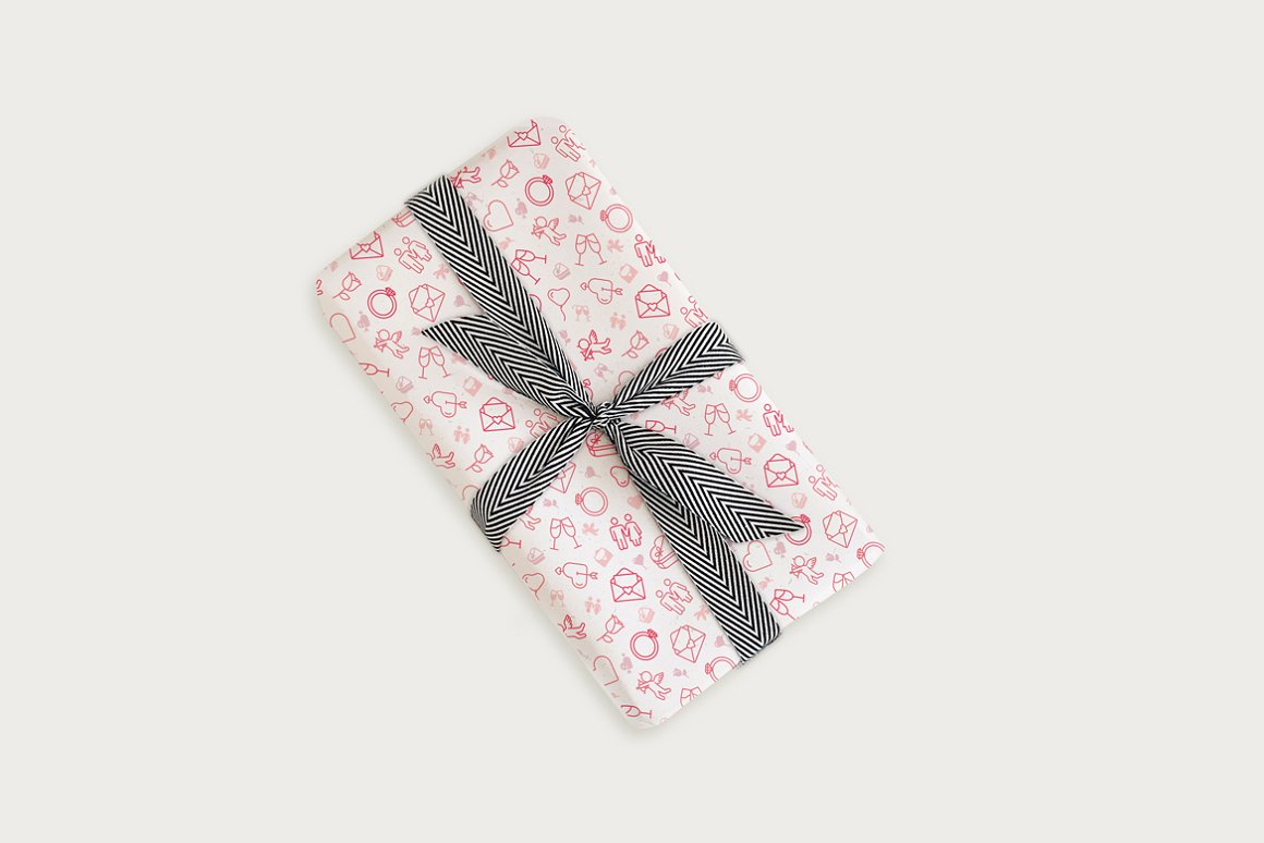 Box in white wrapping paper with red illustrations of iconic valentine on a gray background.