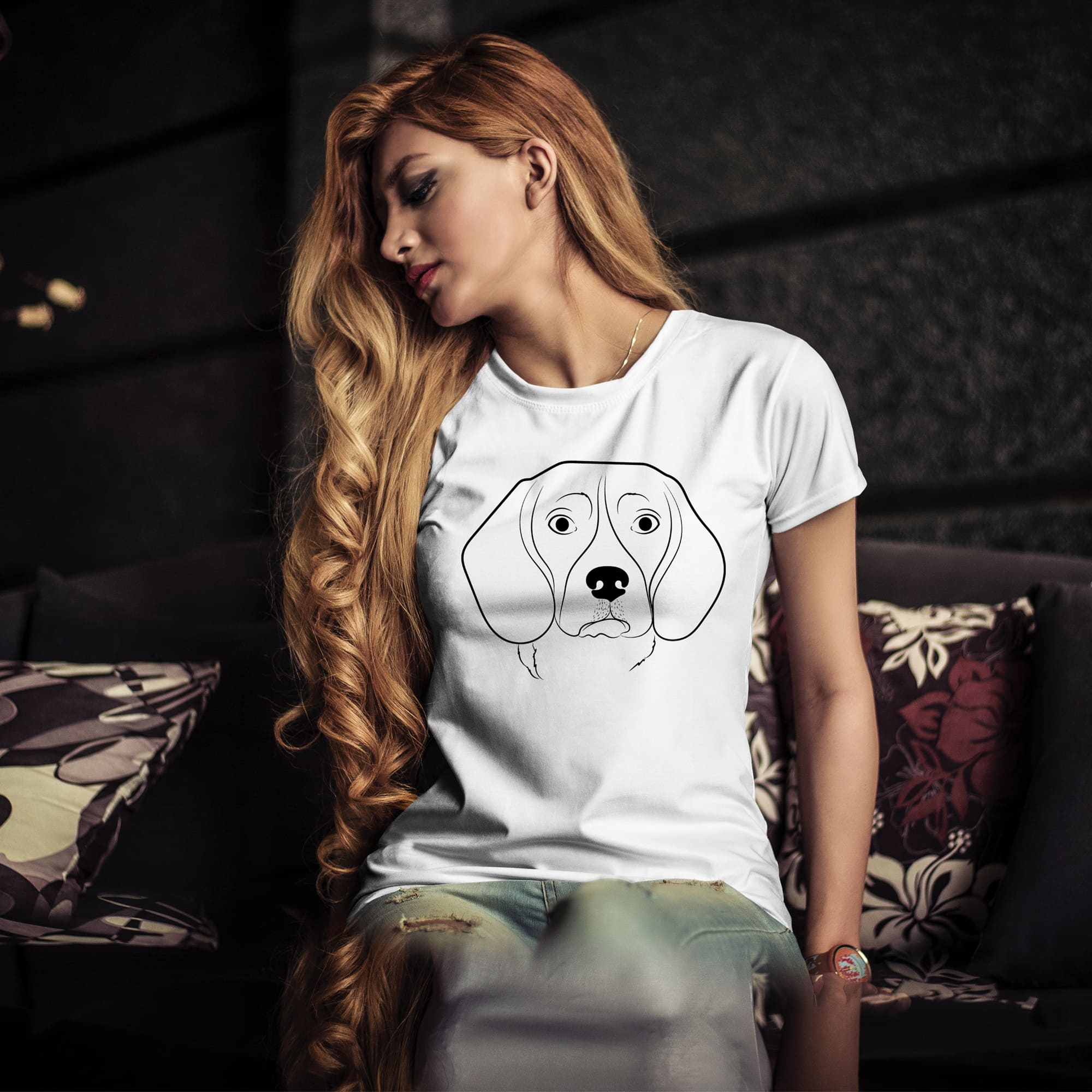 Woman sitting on a couch wearing a t - shirt with a dog's.