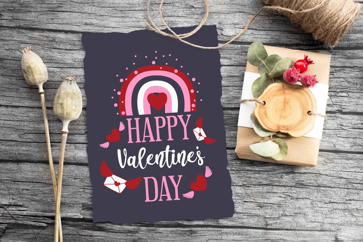 Dark gray card with pink-white lettering "Happy Valentine's day" on the wooden background.