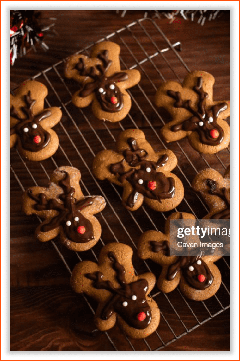 A photo of festive cookies in a shape of deer with chocolate on the top.