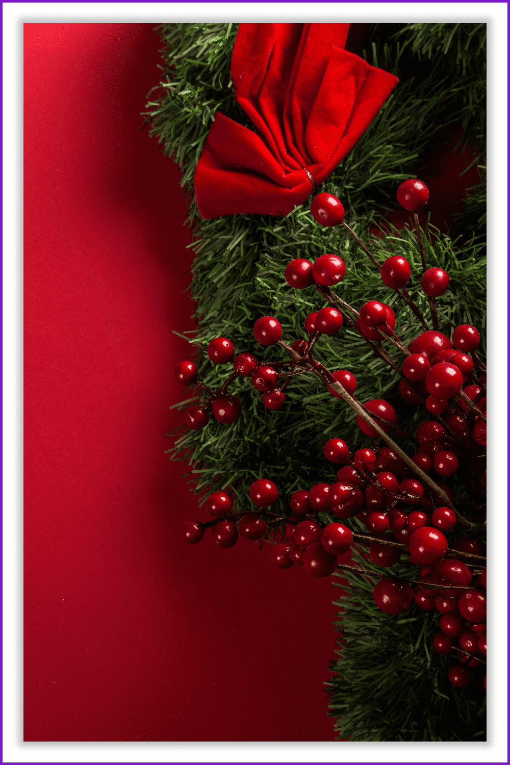 Photo of a Christmas tree branch with red berries and a bow.