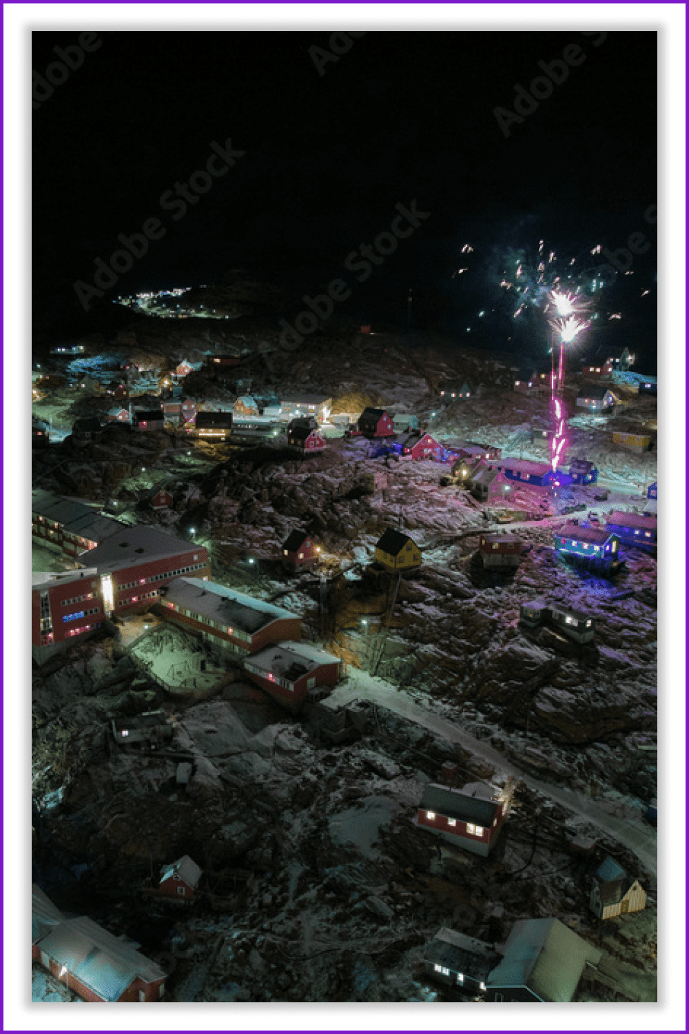Photo of a snow-covered settlement in Greenland and fireworks against a dark sky.