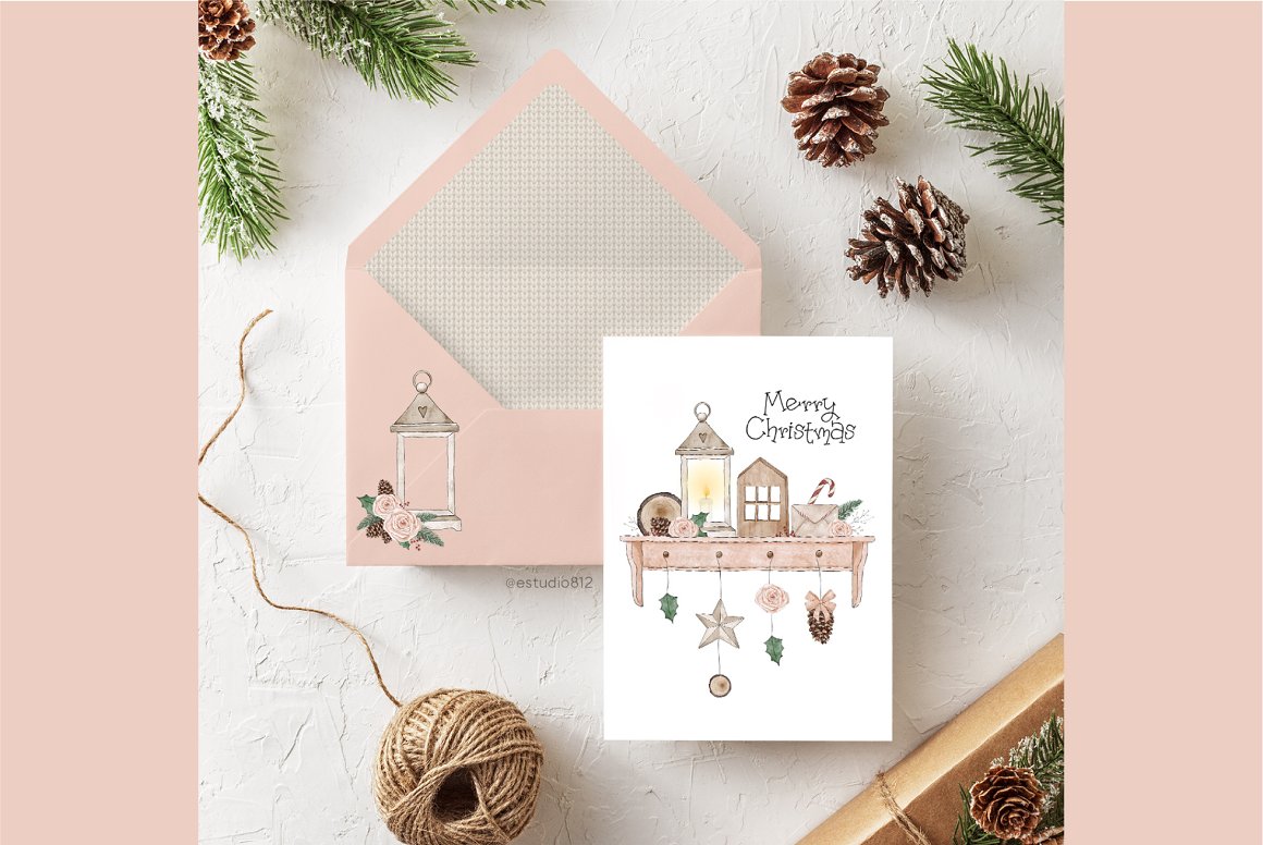 A white greeting card with a watercolor illustration and black lettering "Merry Christmas" and pink envelope.
