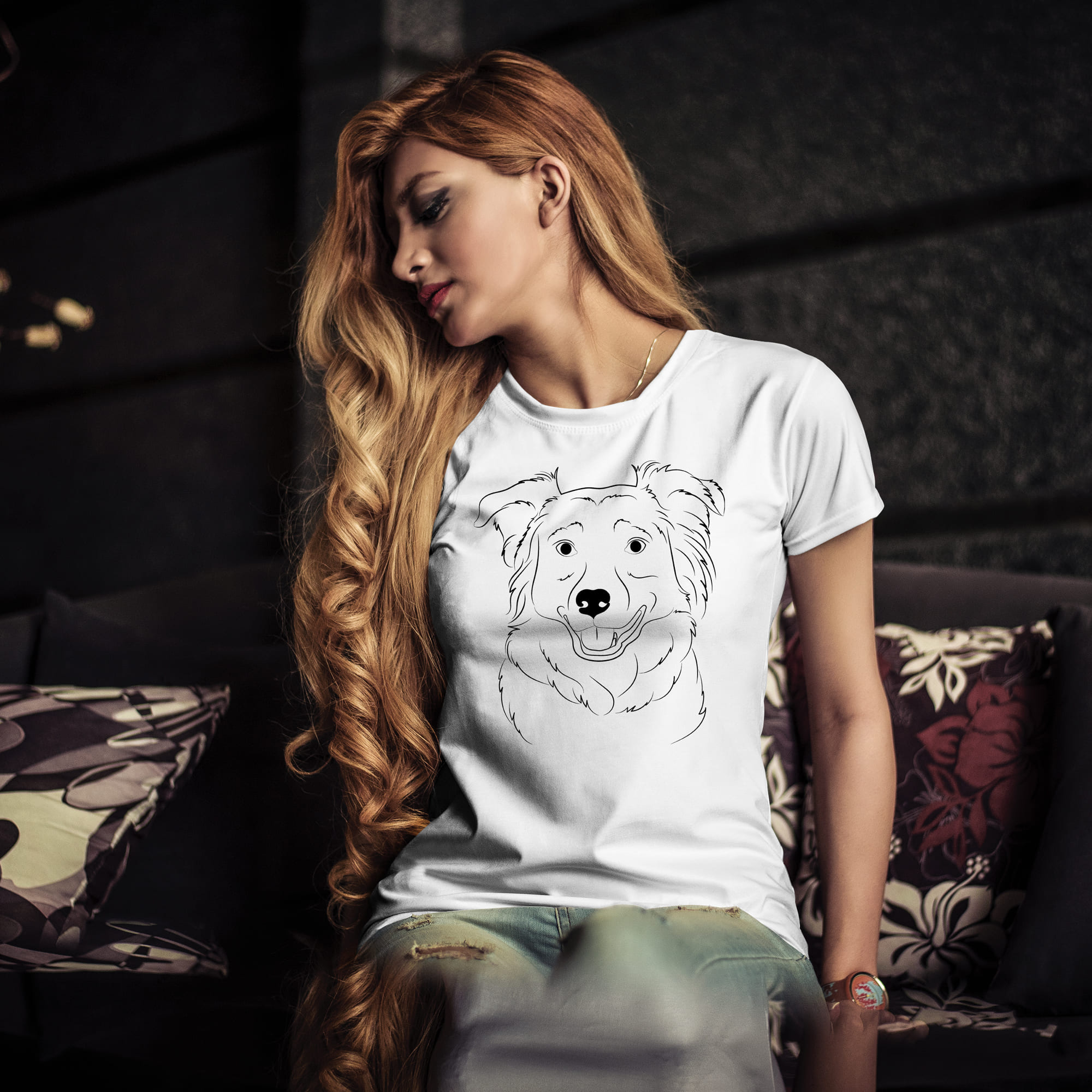 Woman sitting on a couch wearing a t - shirt with a dog on it.