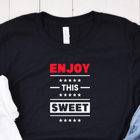 Image of a black t-shirt with a charming inscription "enjoy this sweet" in red and white colors.