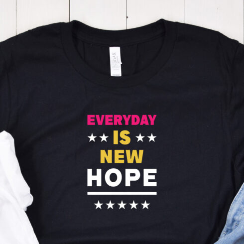 Image of a black t-shirt with a colorful inscription "everyday is new hope" in red and white and yellow colors.