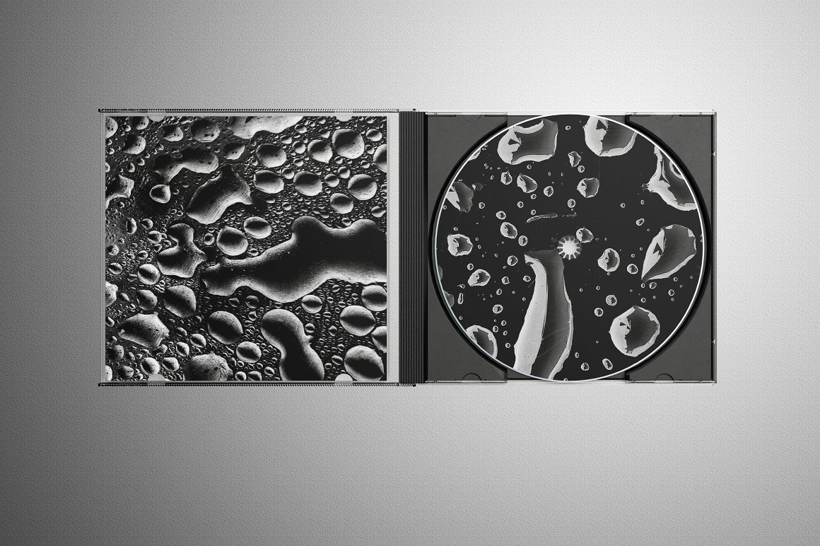 Black CD disk with water drop brushes on a gray background.