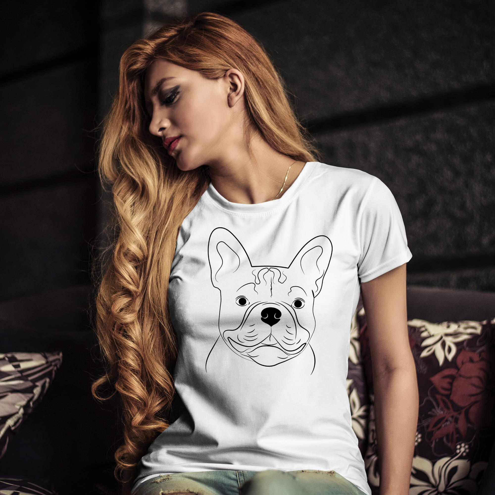 Woman sitting on a couch wearing a t - shirt with a dog on it.