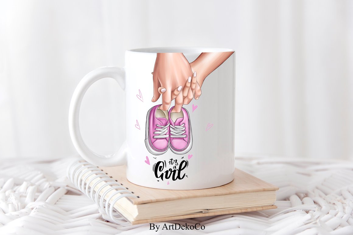 White cup with illustration of hands parents-to-be, black lettering and pink shoes.