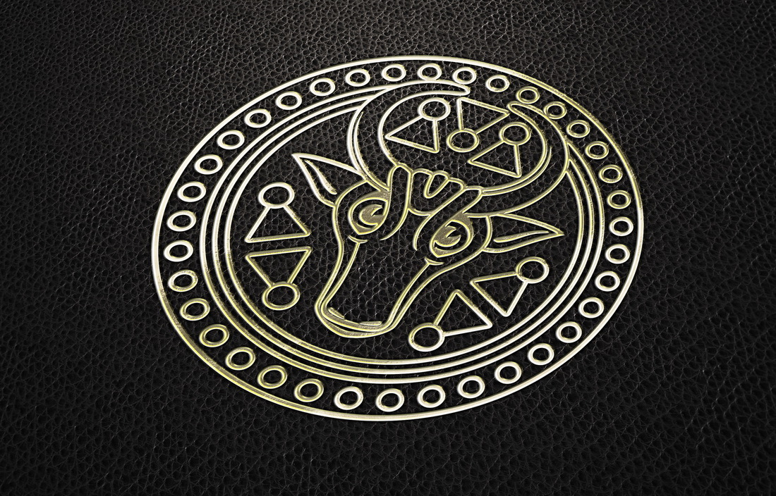 Gold and black logo on a black leather background.