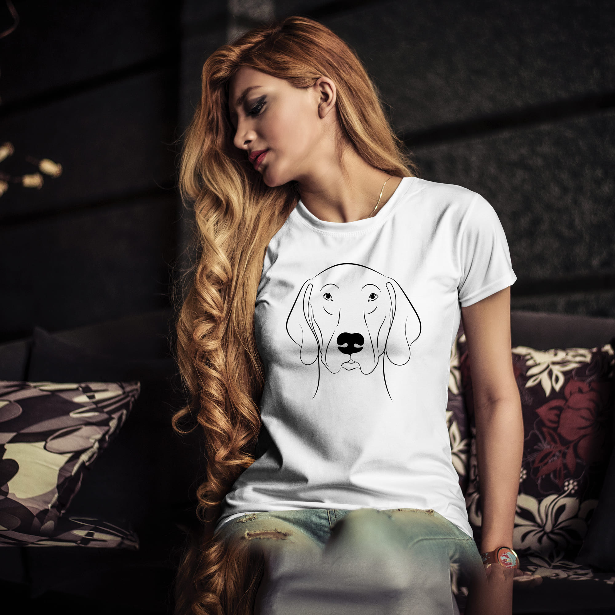 Woman sitting on a couch wearing a t - shirt with a dog's.