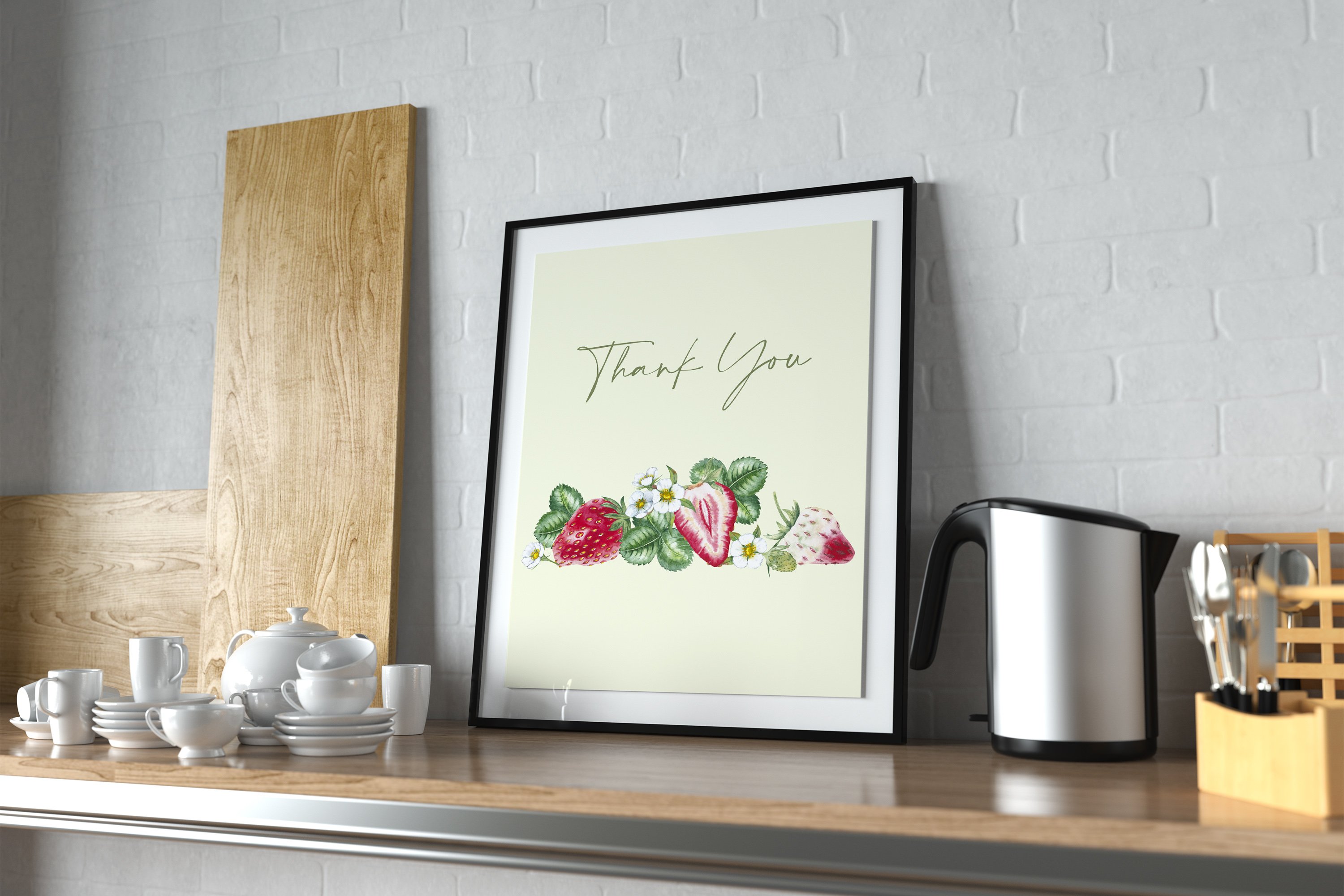 White painting in black frame with black lettering "Thank you" and illustrations of a strawberry.