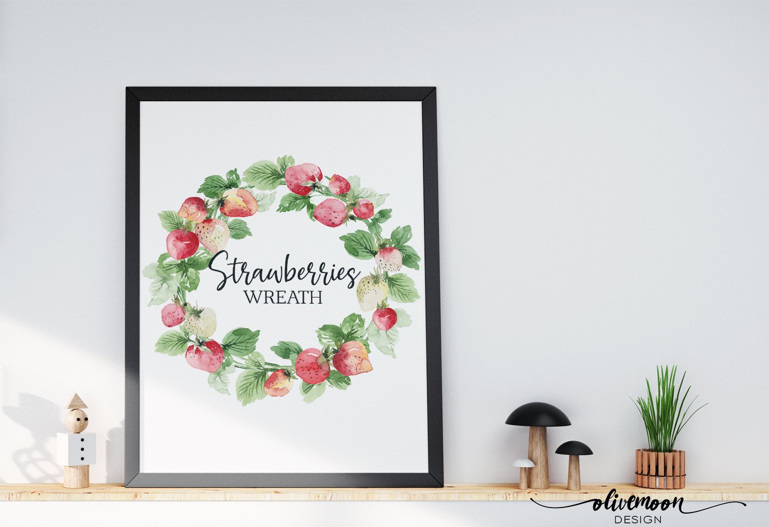 White painting in black frame with black lettering "Strawberry Wreath" in the centre of a strawberry wreath.