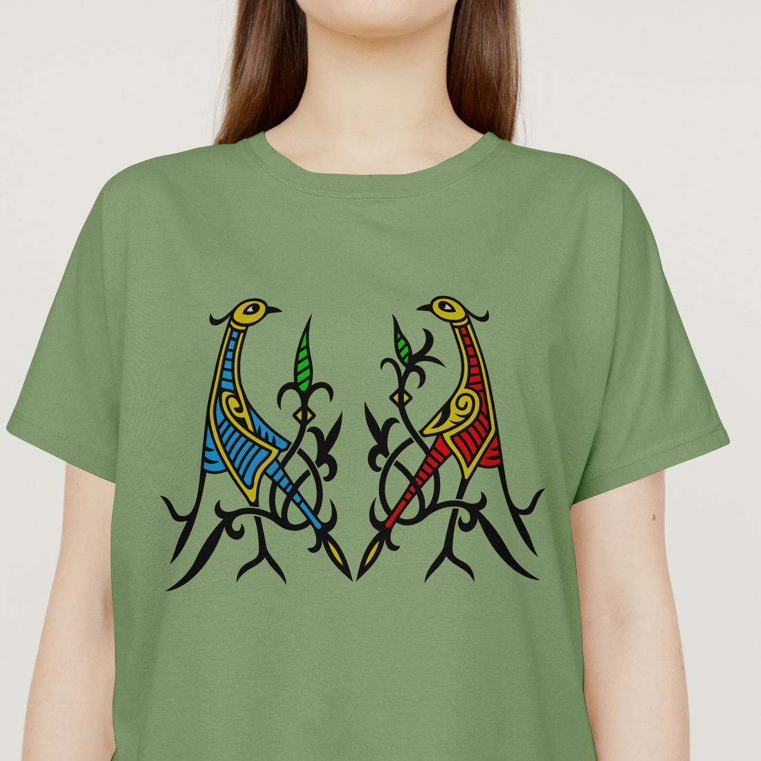 Woman wearing a green t - shirt with two birds on it.