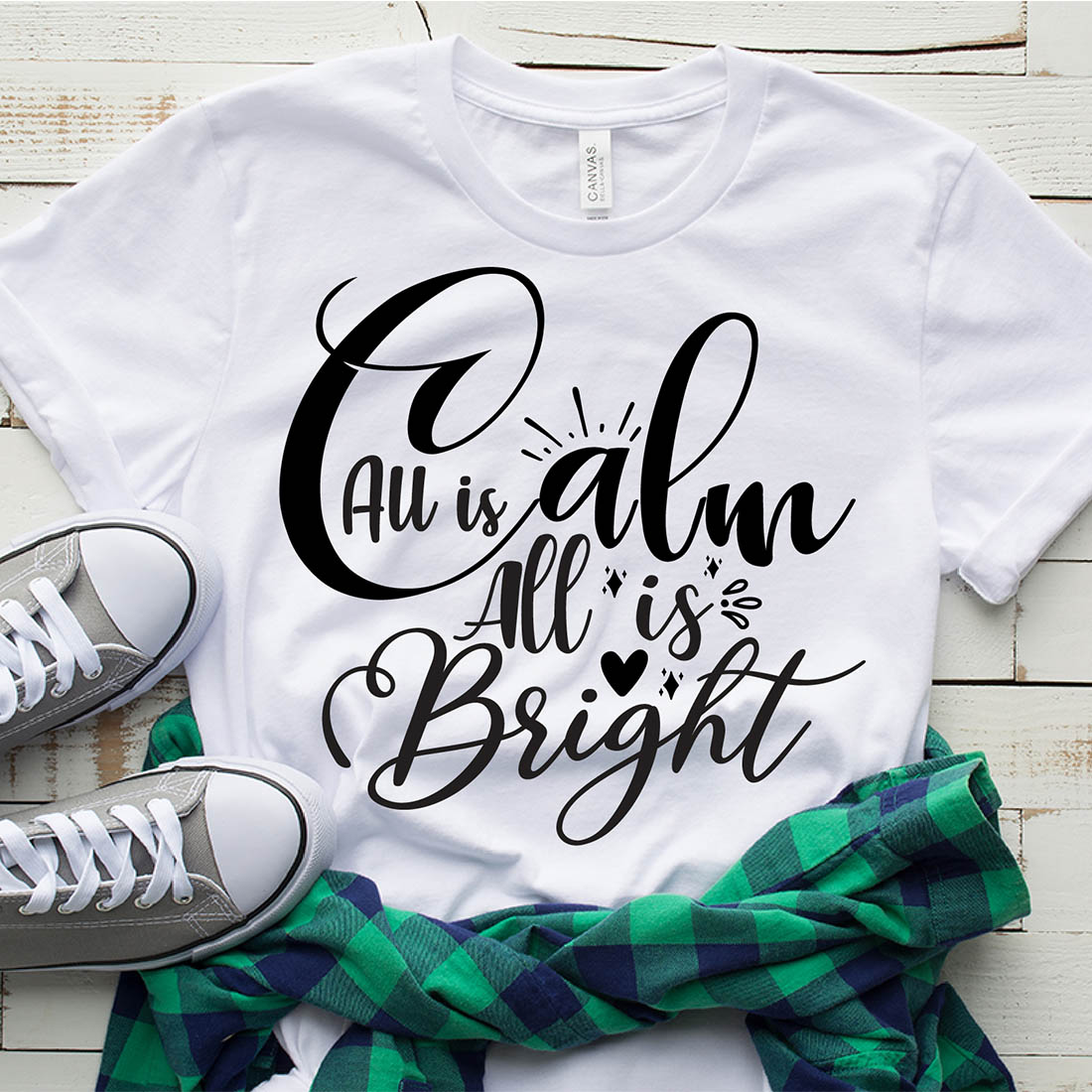 Image of a white t-shirt with a charming black print All Is Calm All Is Bright.