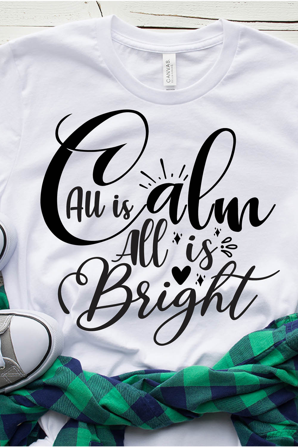 Image of a white t-shirt with a beautiful black print All Is Calm All Is Bright.