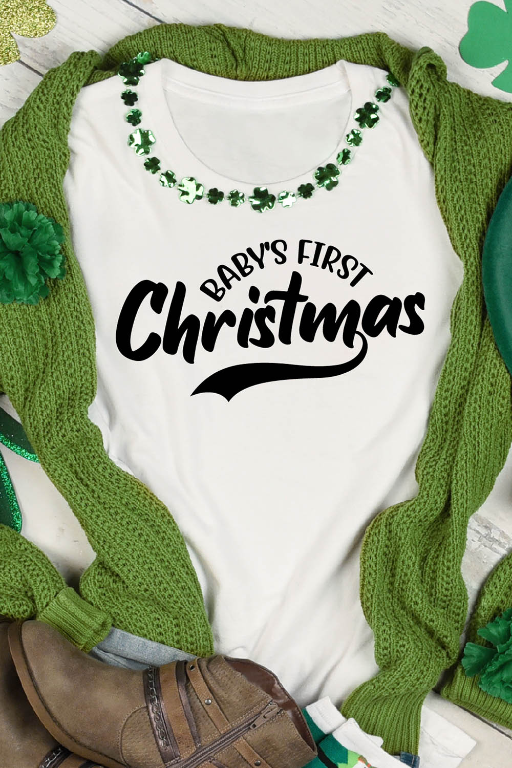 Image of a white t-shirt with an elegant black lettering "Baby's First Christmas".