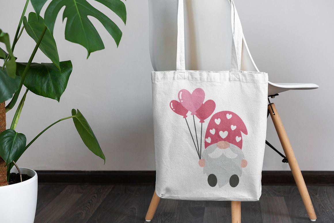 A white shopping bag with illustration of a gnome hold balloons-hearts, on the chair.
