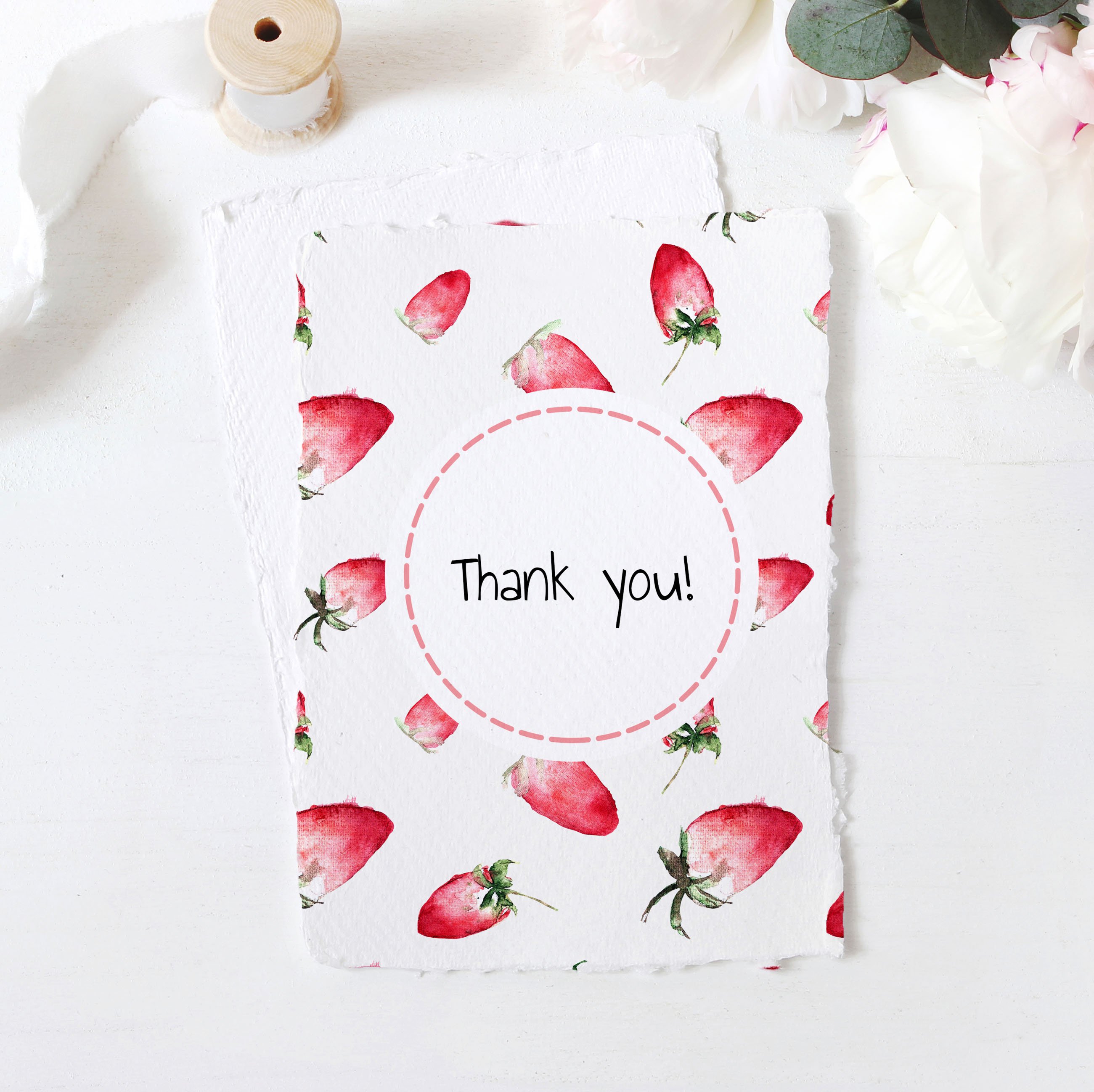 White card with black lettering "Thank you" and illustrations of a strawberry.