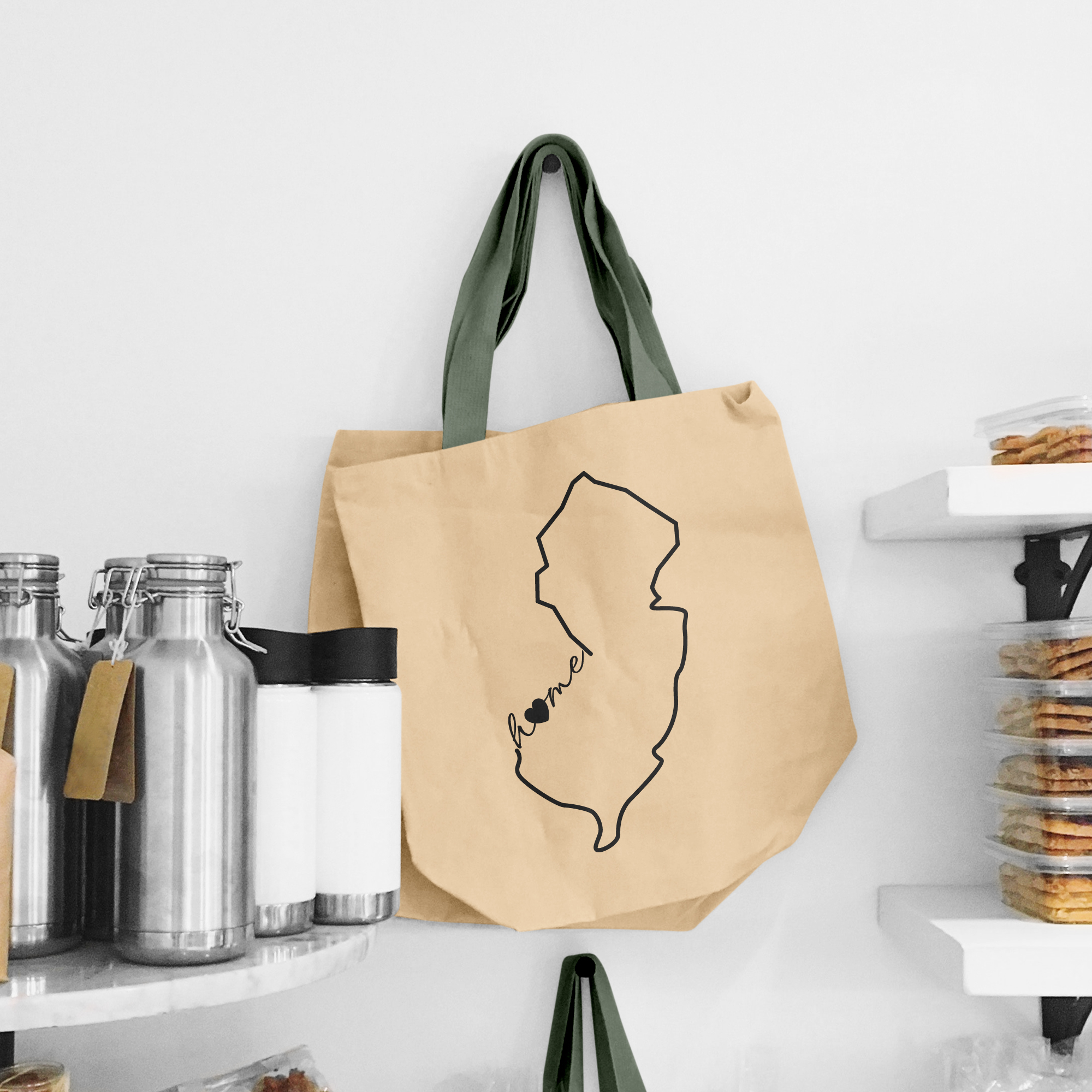 Black illustration of map of New Jersey on the beige shopping bag with dirty green handle.