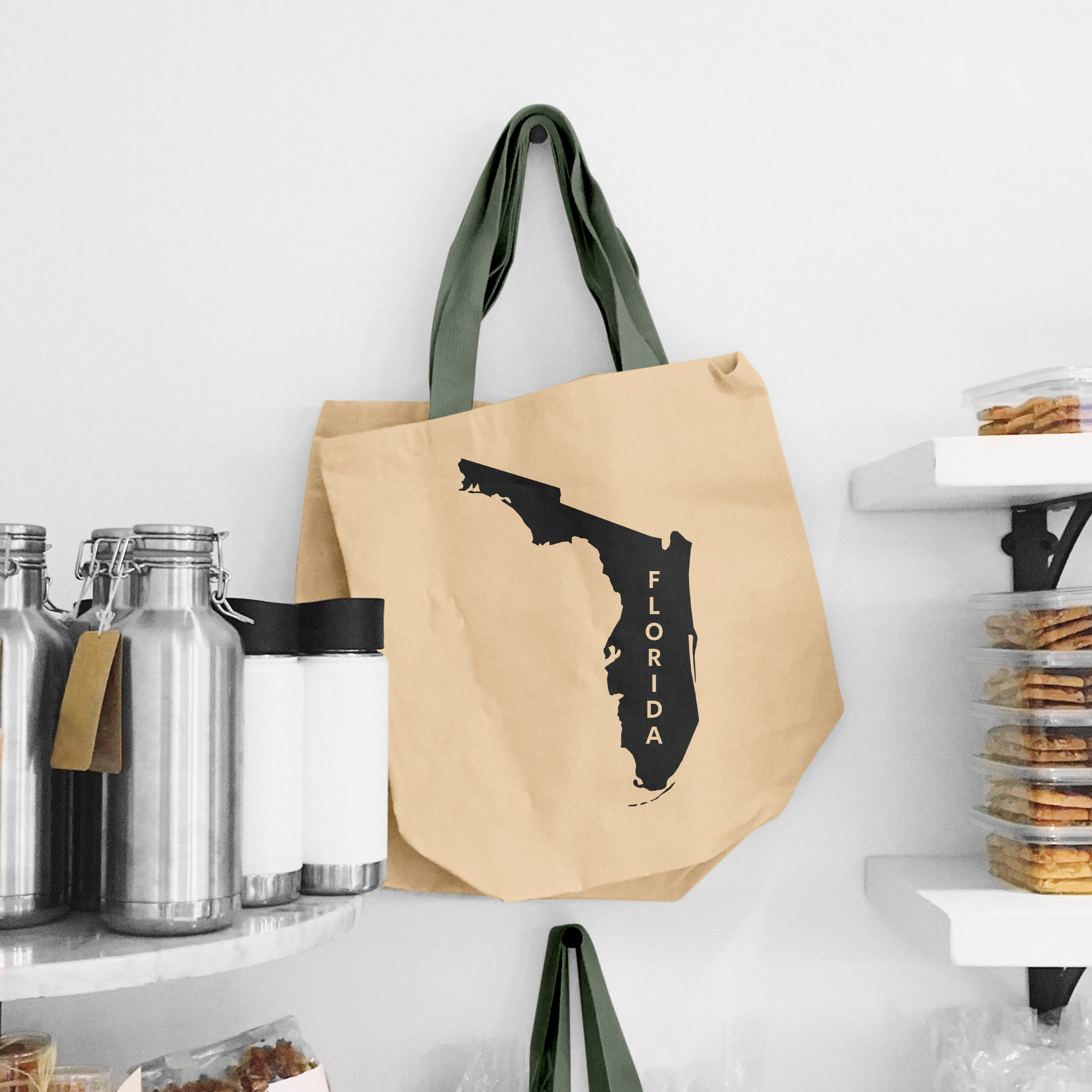 Black illustration of map of Florida and lettering "Florida" on the beige shopping bag with dirty green handle.