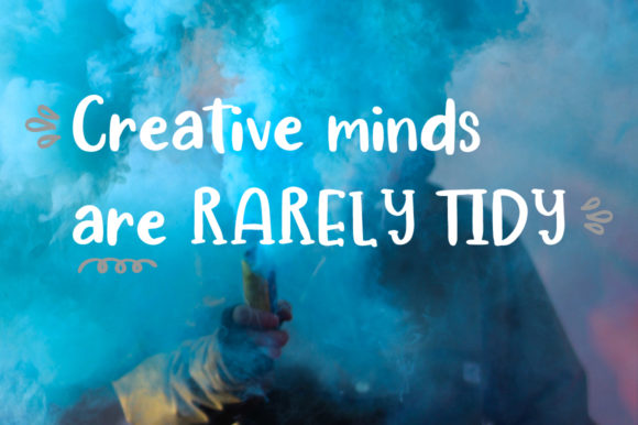 White calligraphy lettering "Creative minds are rarely tidy".