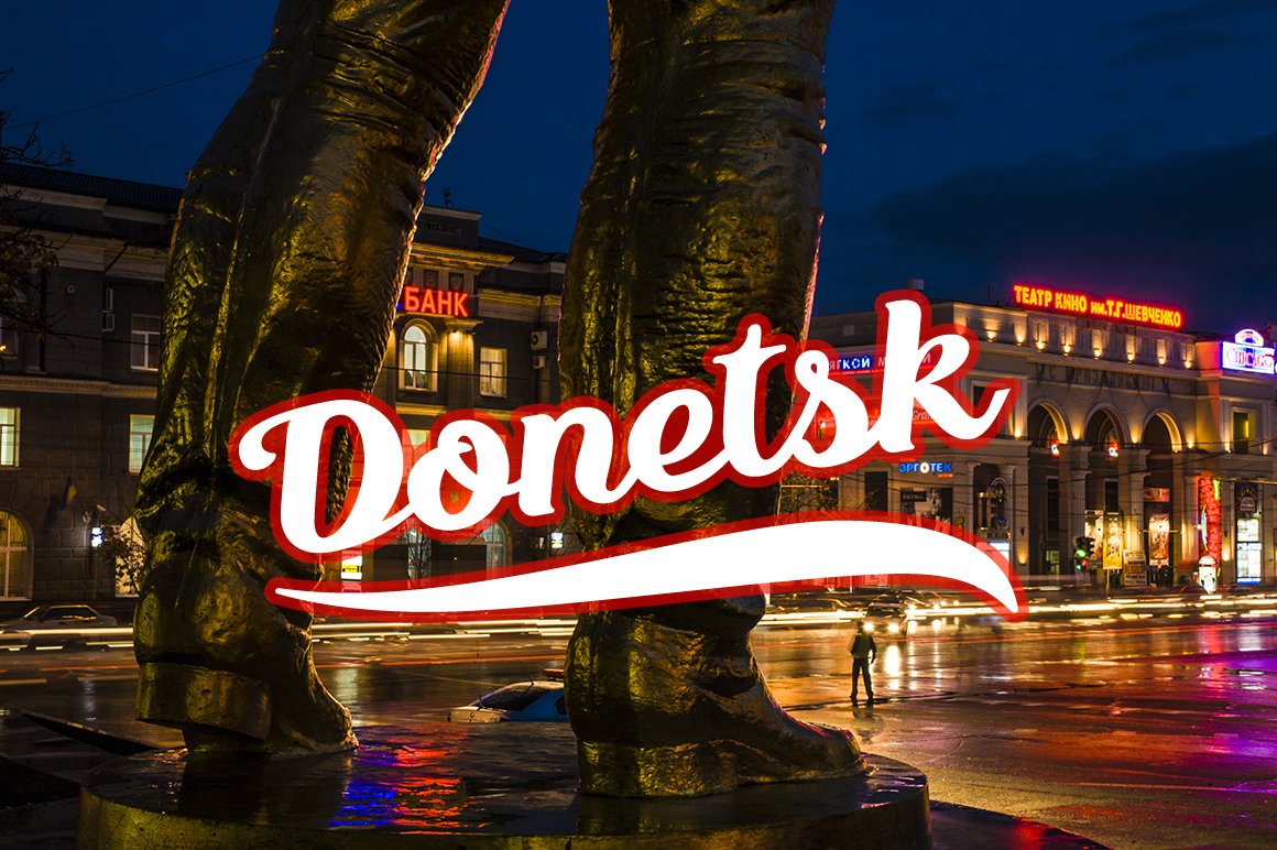 Red and white calligraphy lettering "Donetsk" on the background of this city.
