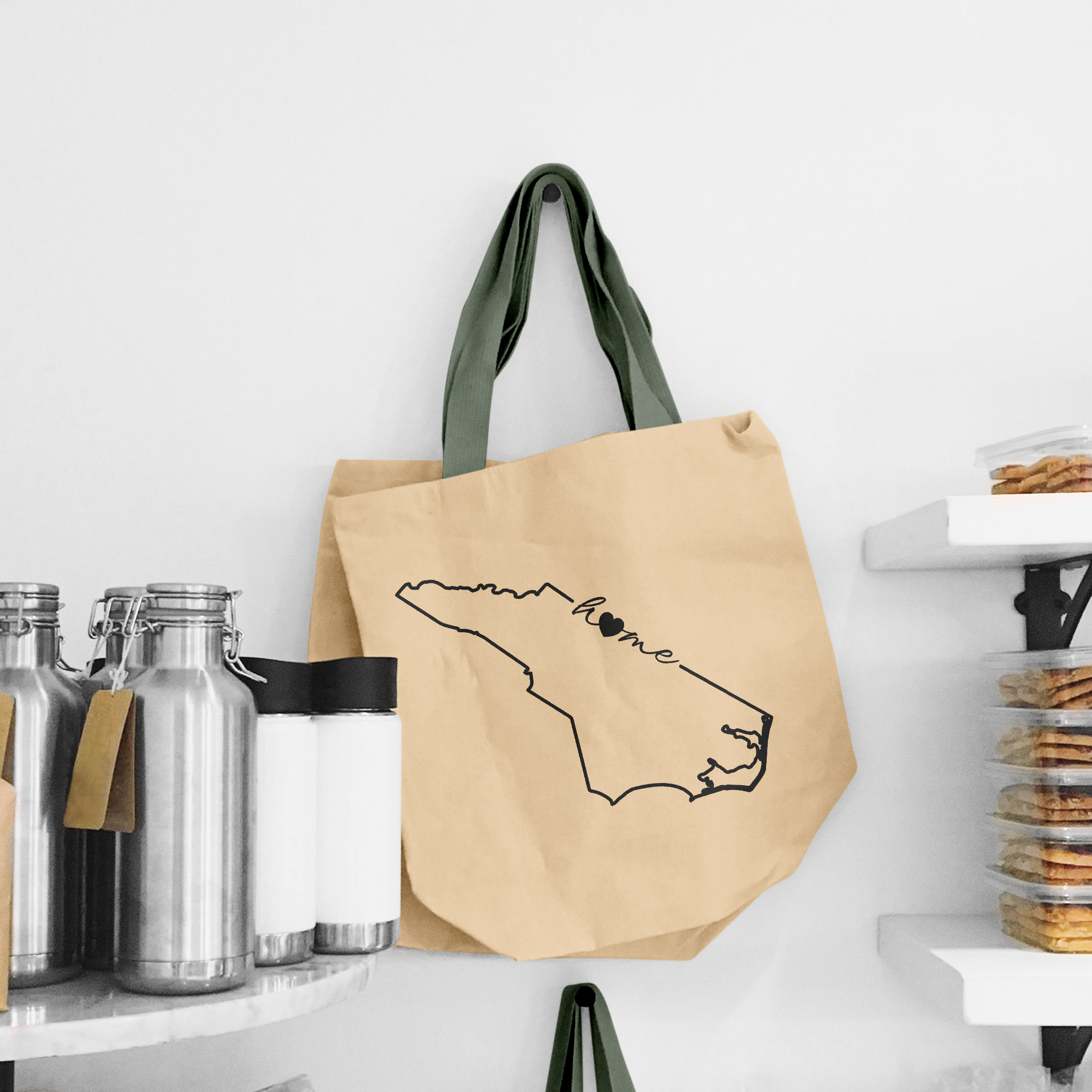 Black illustration of map of North Carolina on the beige shopping bag with dirty green handle.