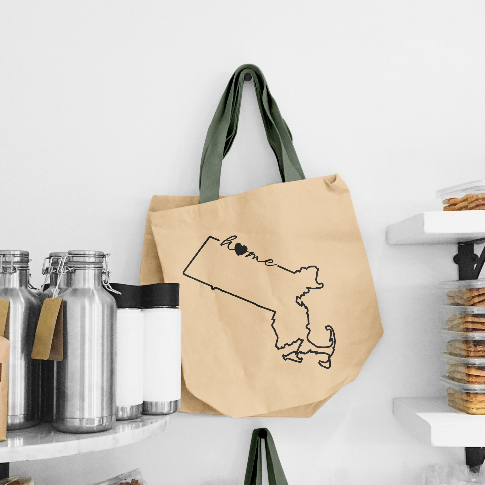 Black illustration of map of Massachusetts on the beige shopping bag with dirty green handle.