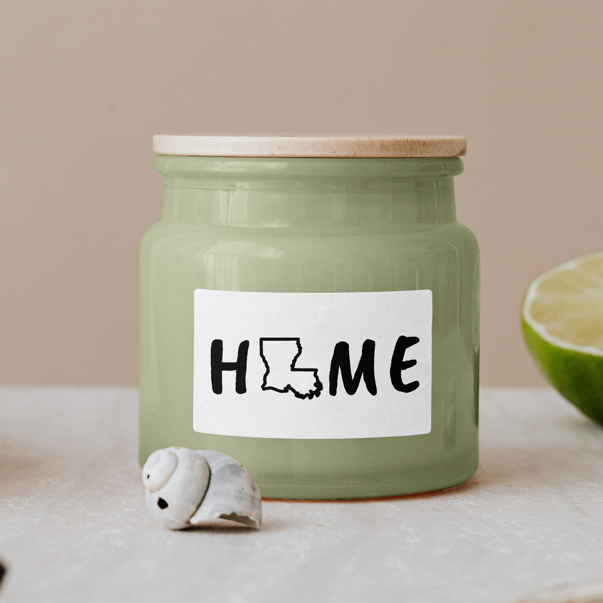 Black lettering "Home" on a white label on a green glass jar with wooden lid.