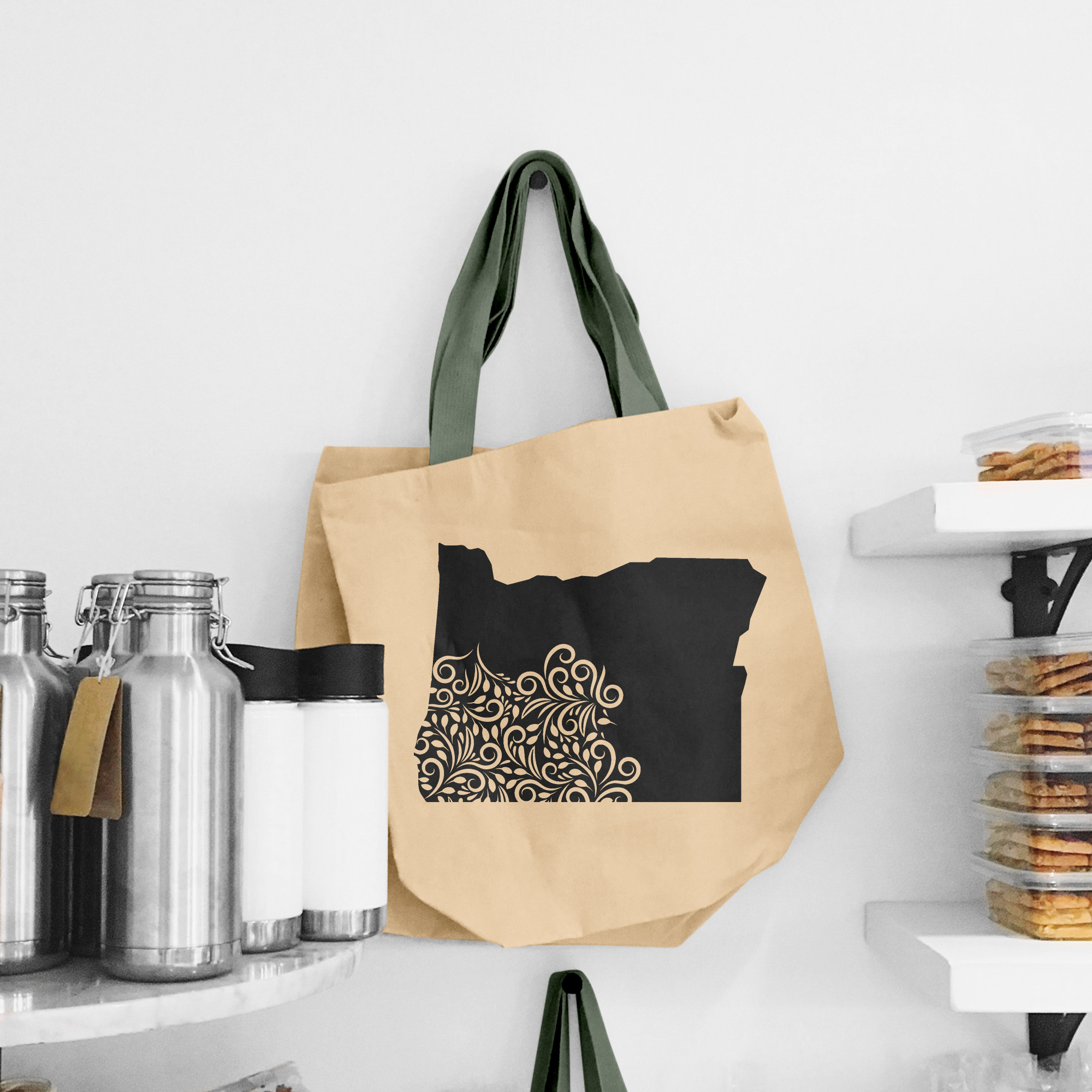 Black illustration of map of Oregon on the beige shopping bag with dirty green handle.