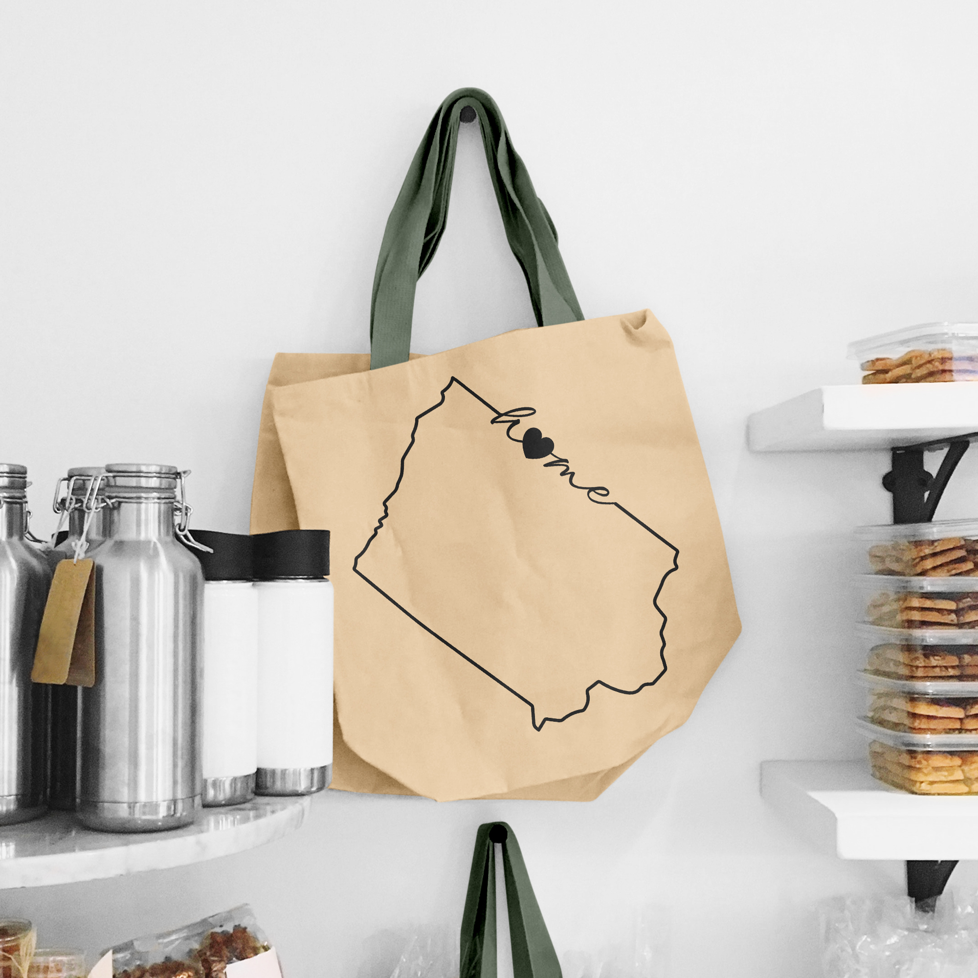 Black illustration of home on the beige shopping bag with dirty green handle.