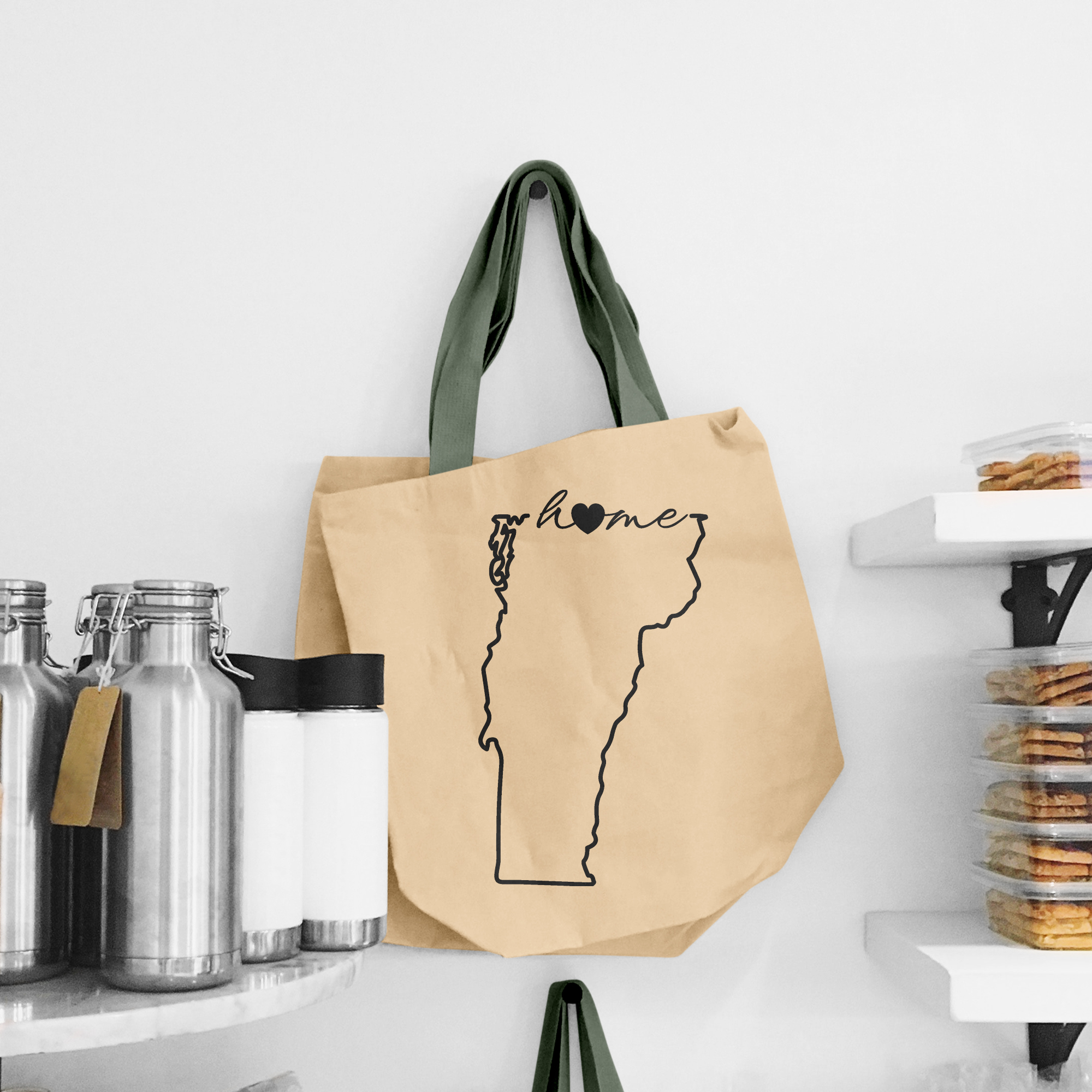 Black illustration of map of Vermont on the beige shopping bag with dirty green handle.