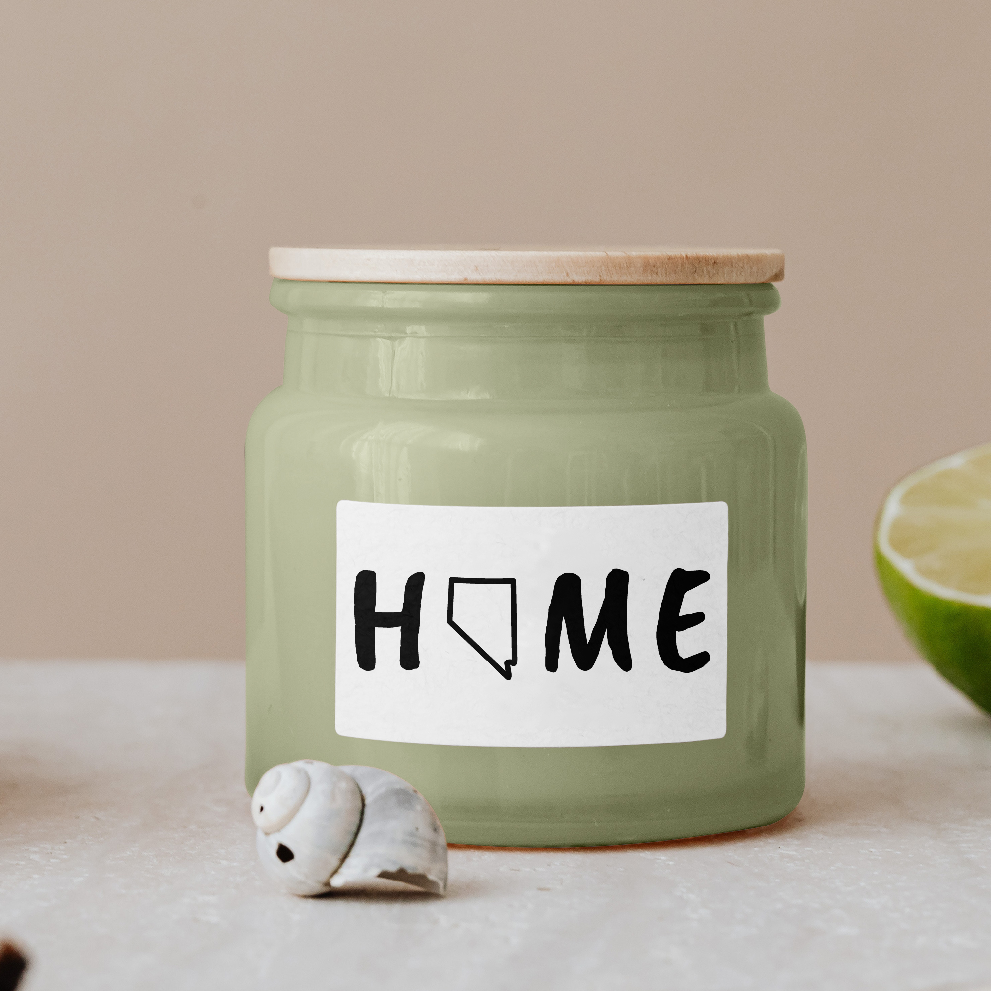 Black lettering "Home" on a white label on a green glass jar with wooden lid.